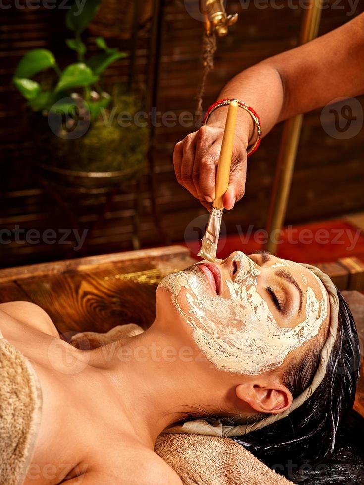 Eine Frau, die sich im Ayurveda-Spa in eine Handtuchmaske legt foto