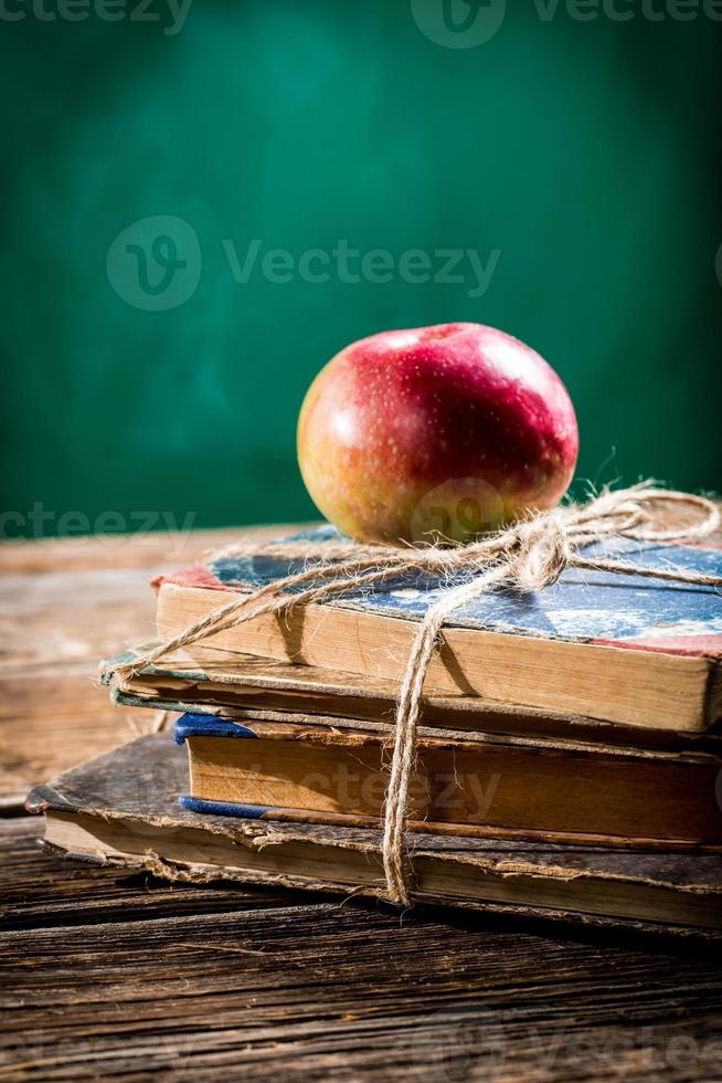 alte Bücher und Apfel auf der Schulbank foto