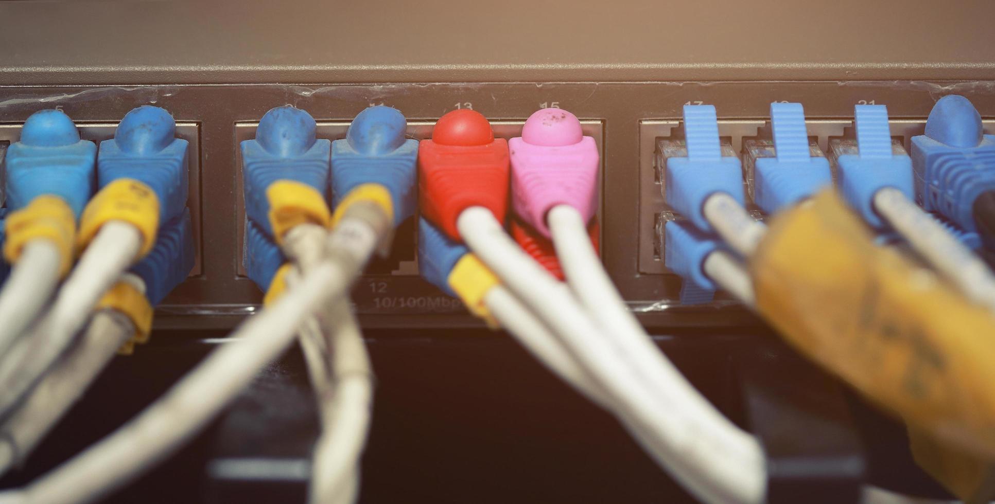 technologiezentrum netzwerkserverraum mit netzwerkkabeln, die an ethernet-ports angeschlossen sind. Ausrüstung des Internetdienstanbieters. Fokus auf Kabel. Hardwarekonzept für Datennetzwerke. foto