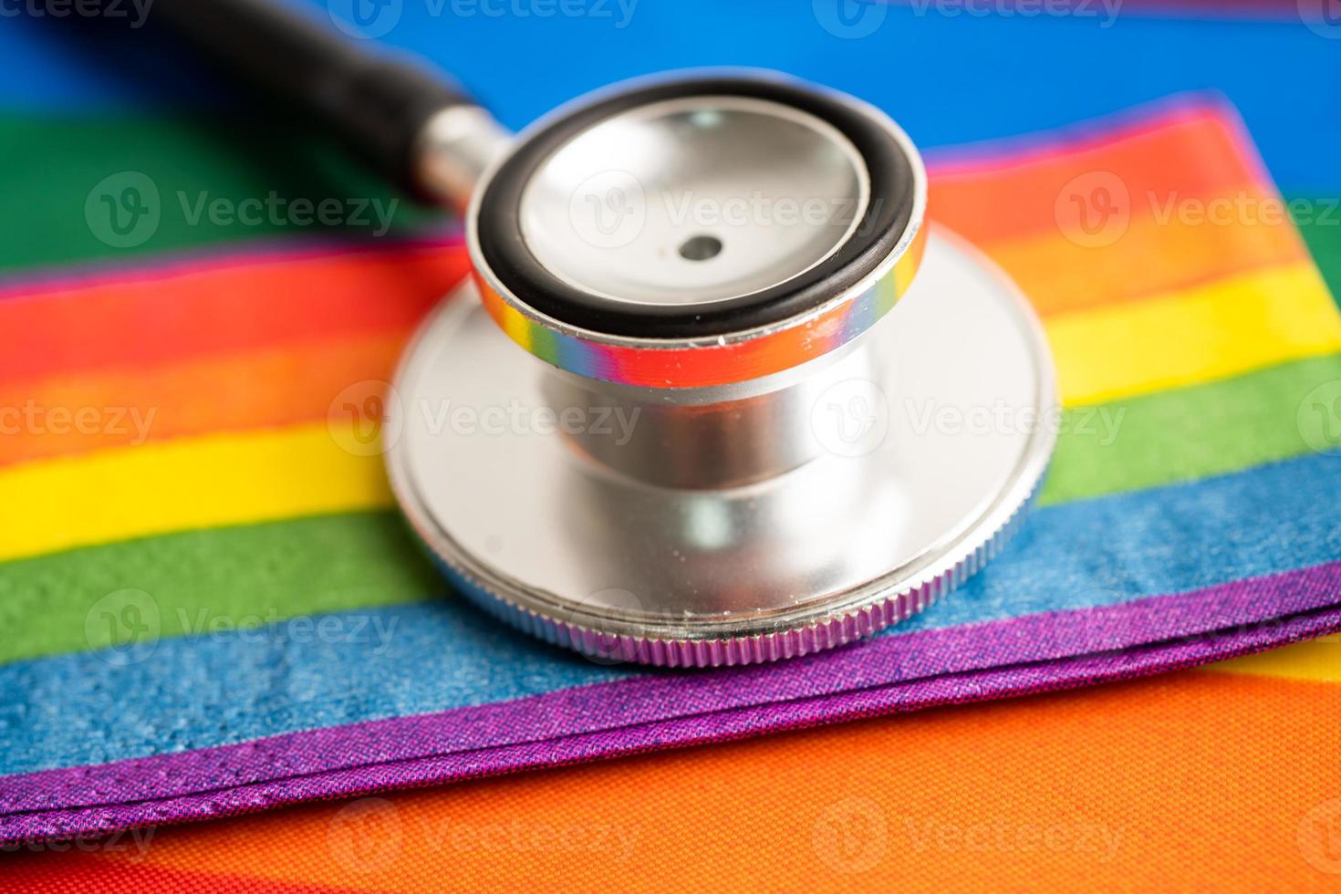 schwarzes stethoskop mit regenbogenflaggenherz auf weißem hintergrund, symbol des lgbt-stolzmonats feiern jährlich im juni sozial, symbol für schwule, lesbische, bisexuelle, transgender, menschenrechte und frieden. foto