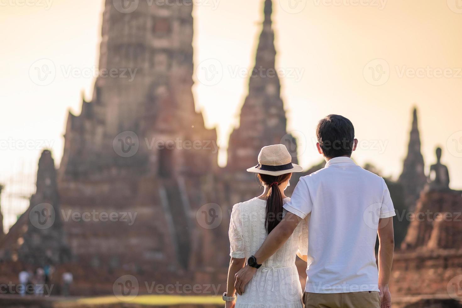 paar touristen tragen chirurgische gesichtsmaske, schutz covid-19 pandemie während des besuchs im wat chaiwatthanaram tempel in ayutthaya. neues normal-, sicherheitsreise- und thailand-reisekonzept foto