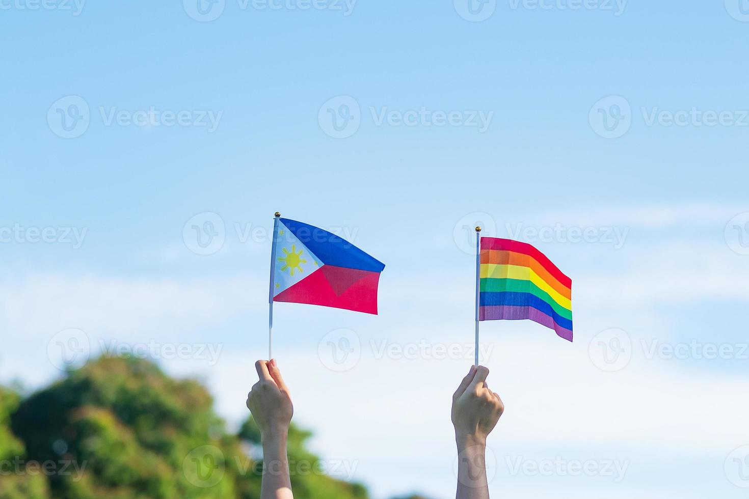 hände, die lgbtq-regenbogen und philippinische flagge auf naturhintergrund zeigen. Unterstützen Sie das Konzept der Lesben-, Schwulen-, Bisexuellen-, Transgender- und Queer-Community und des Pride-Monats foto