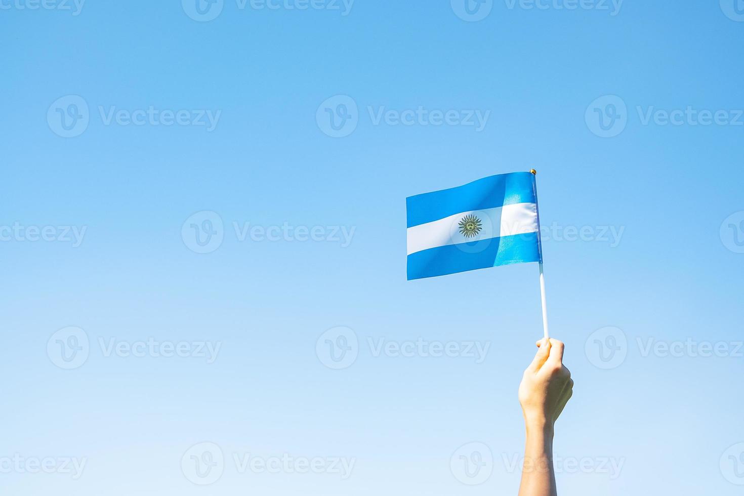 Hand, die Argentinien-Flagge auf Naturhintergrund hält. 9. juli unabhängigkeitstag, 25. mai revolutionstag und fröhliche feierkonzepte foto