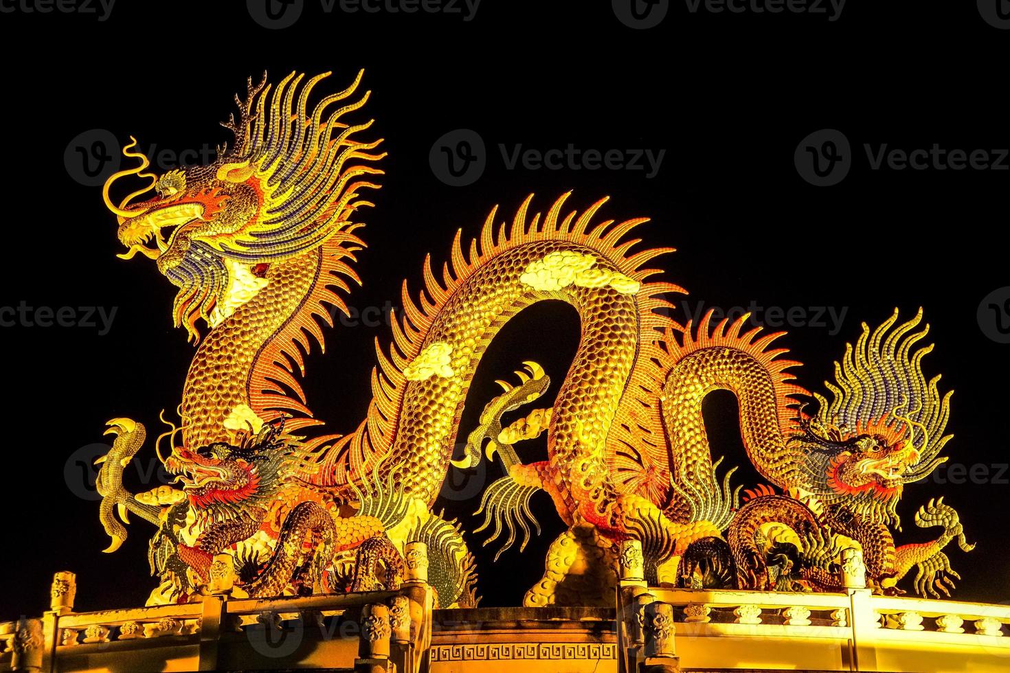 Die goldene Statue im chinesischen Stil eines prächtigen goldenen Königsdrachen mit nachts beleuchtetem Licht. foto