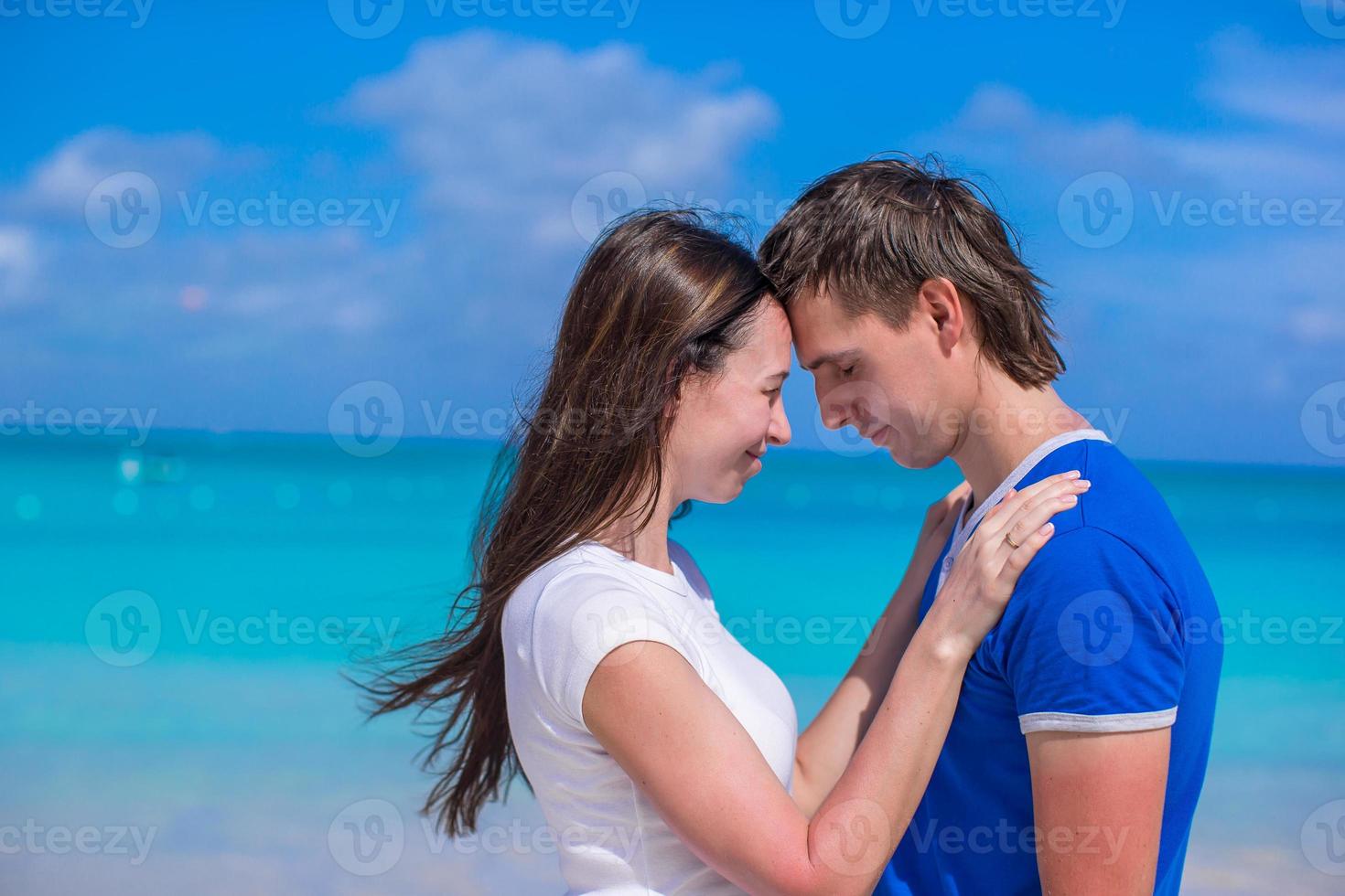 glückliches junges Paar, das Sommerferien am tropischen Strand genießt foto