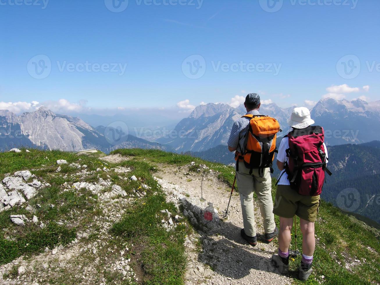 Wanderer auf dem Berg genießen die Aussicht, bevor sie wieder hinunter gehen foto