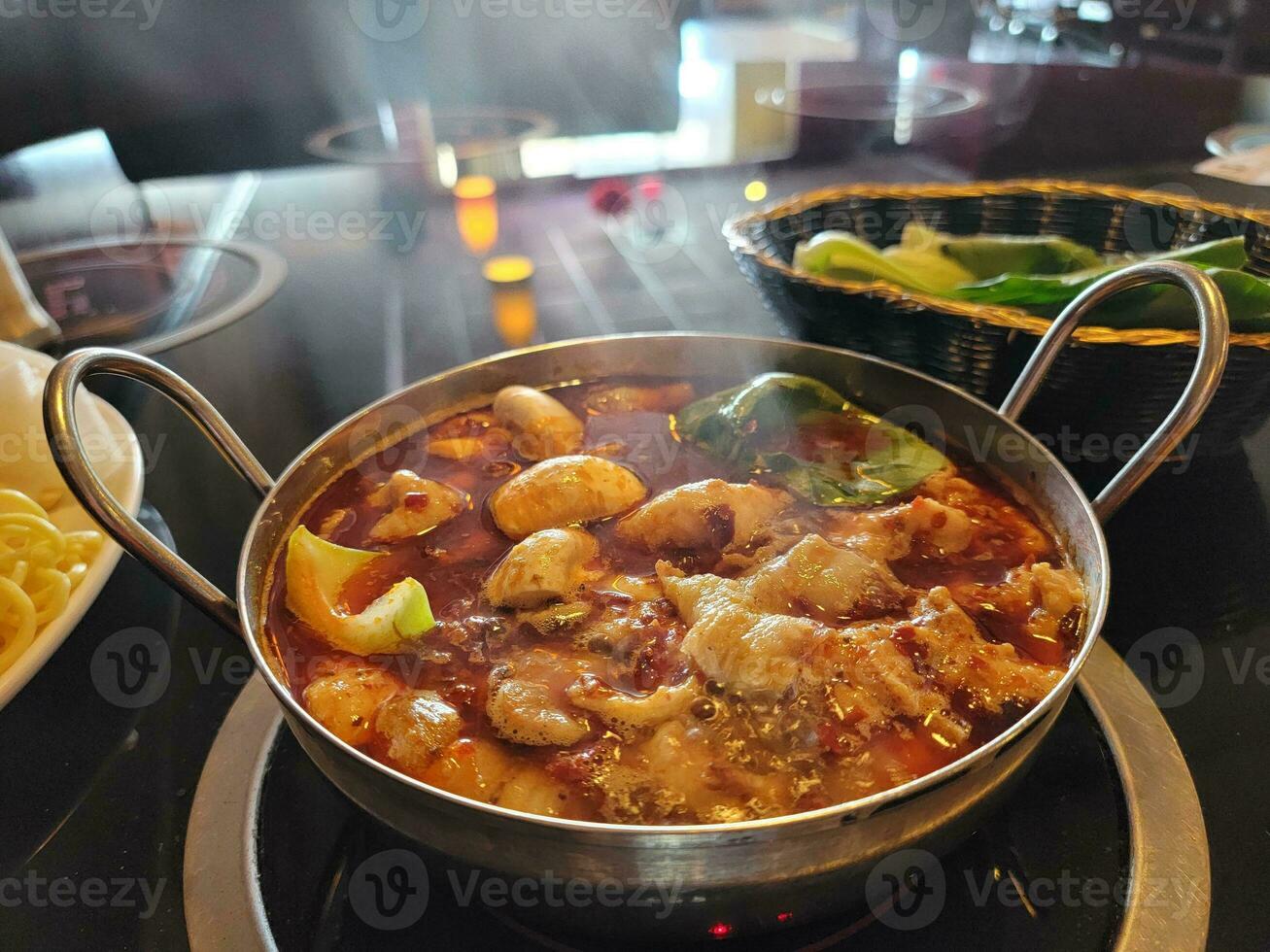 chinesischer heißer topf mit würziger brühe in schüssel mit fleisch und gemüse foto