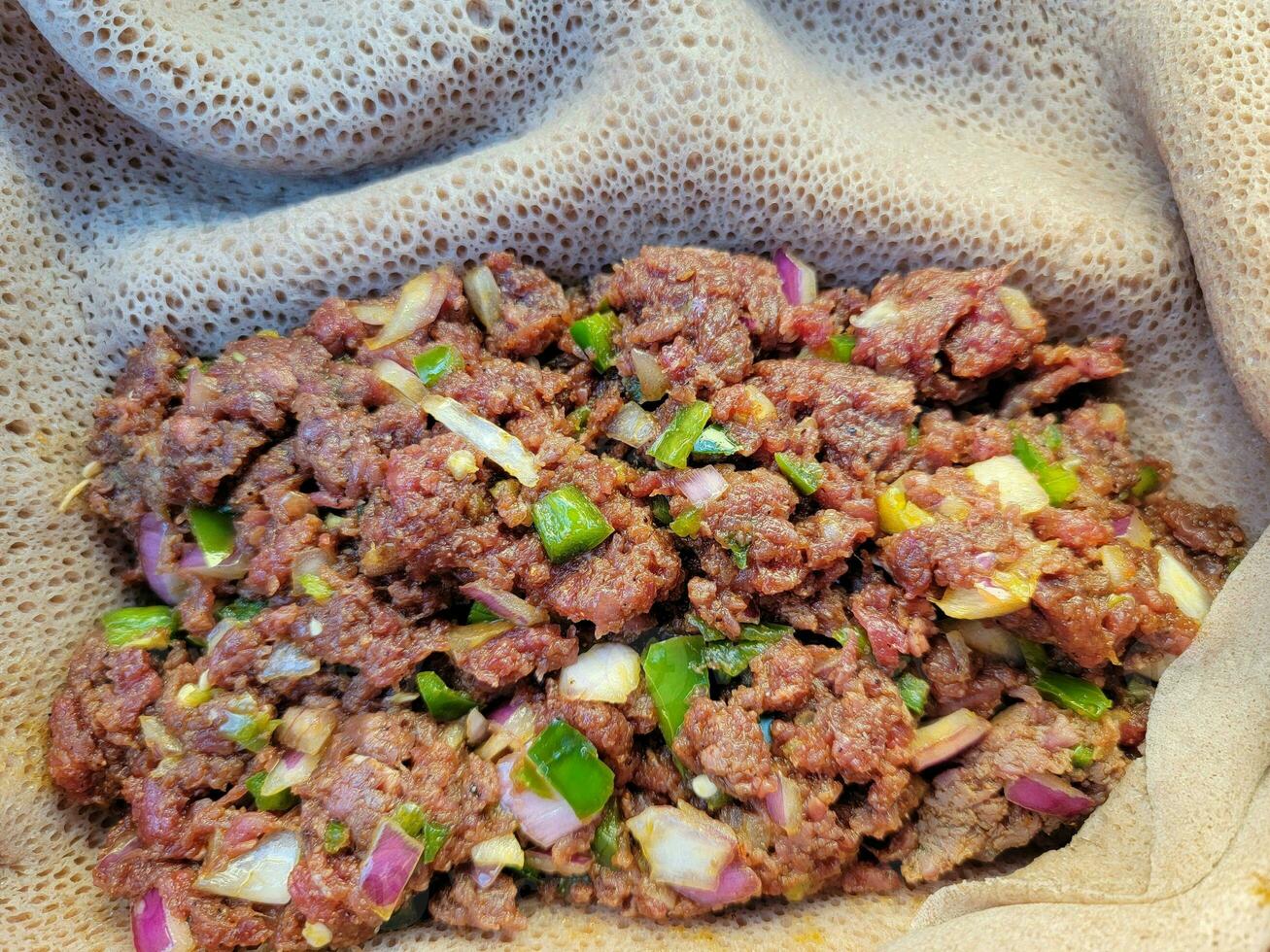 Äthiopische Delikatesse aus rohem Rindfleisch namens Kitfo mit Brot und Paprika foto