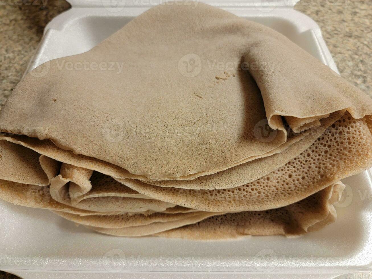 Schaumbehälter mit Stapel äthiopischem Brot namens Injera foto