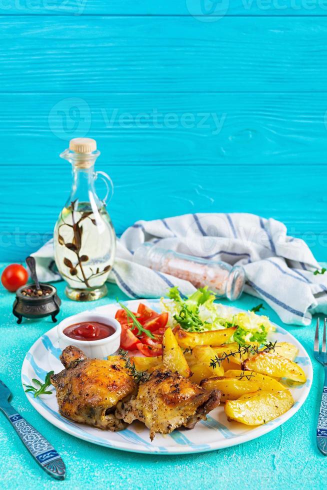 köstliches gebackenes Hähnchen mit Kartoffeln auf blauem Hintergrund foto