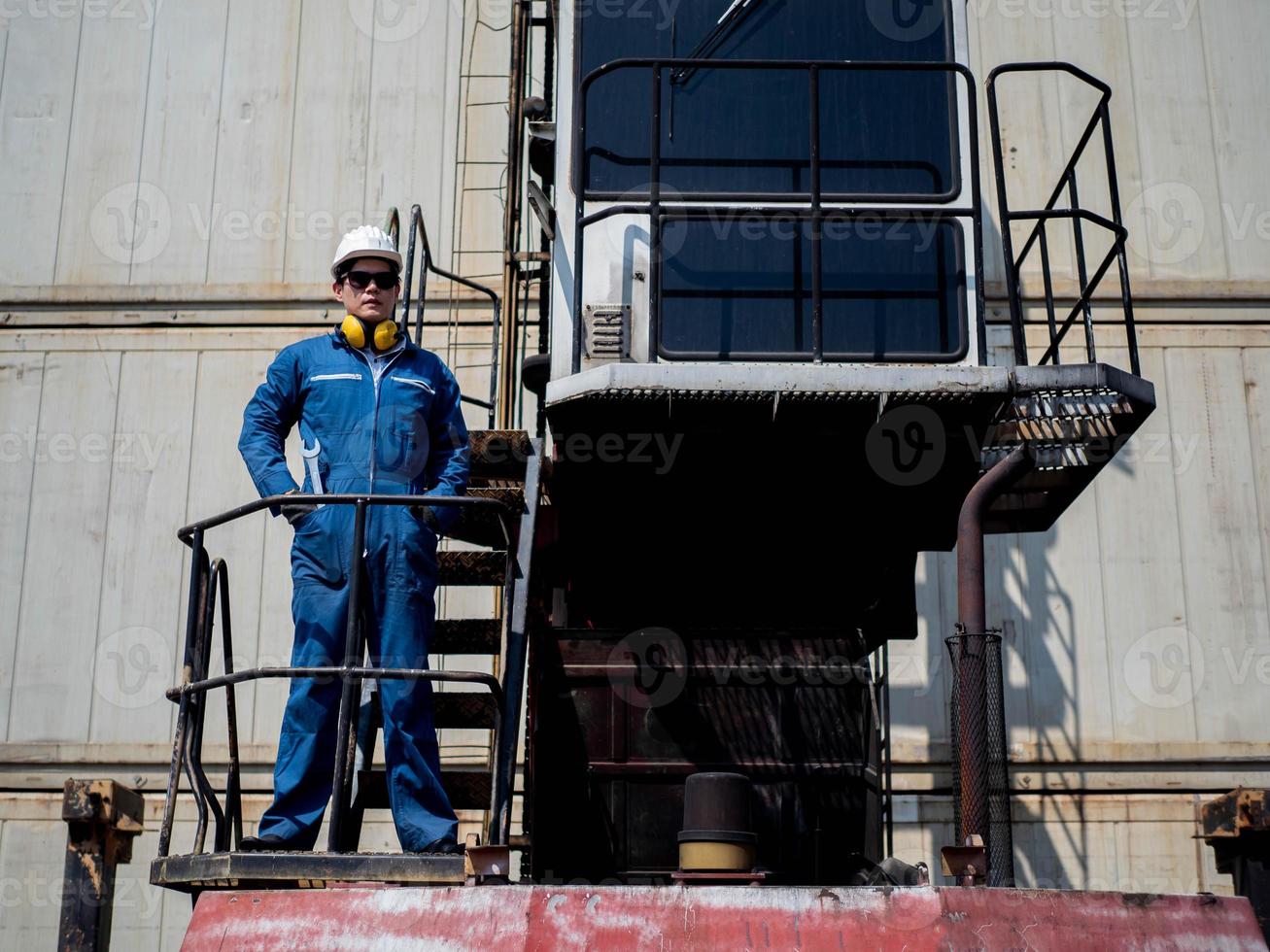 vorarbeiter ingenieur männlich helm helm weiß blau sicherheit stehend blick kamera arbeit job karriere einfuhr export technik gabelstapler container versand lieferung logistik güterverkehr kaufmännisch kontrolle foto