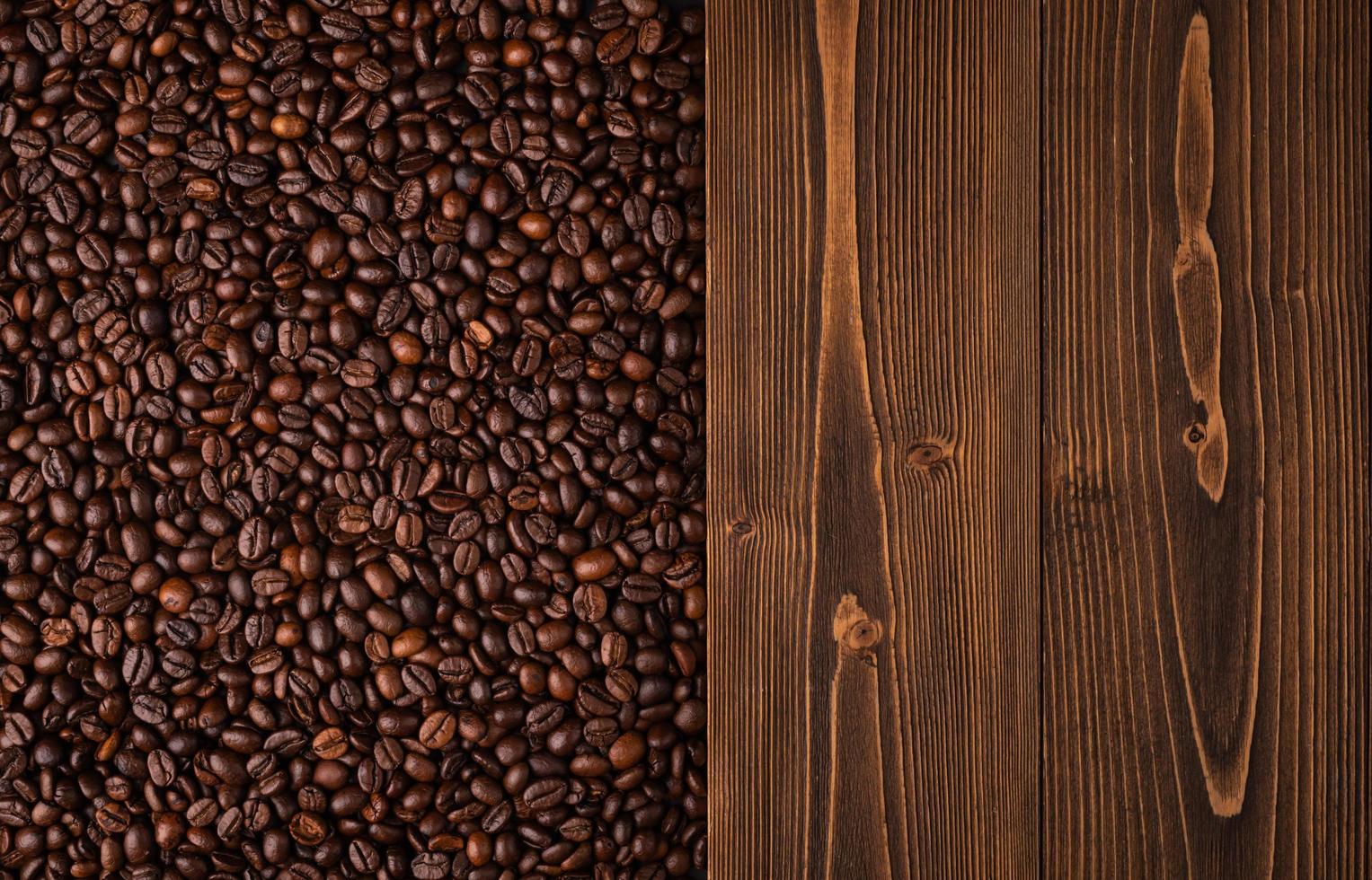 geröstete kaffeebohnen und holzstruktur. braune kaffeebohnenbeschaffenheit der draufsicht für hintergrund- und tapetengebrauch foto