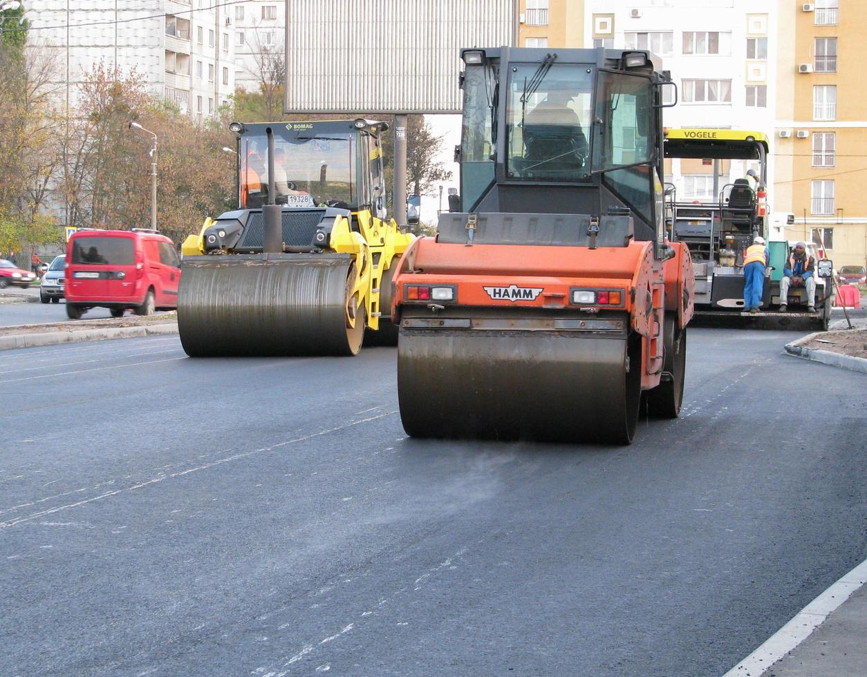 ukraine, charkiw, 27. oktober 2020. nahansicht der arbeiter und der asphaltiermaschinen. Walze und Arbeiter bei der Asphaltierung und Reparatur von Straßen der Stadt. hochwertiges Foto