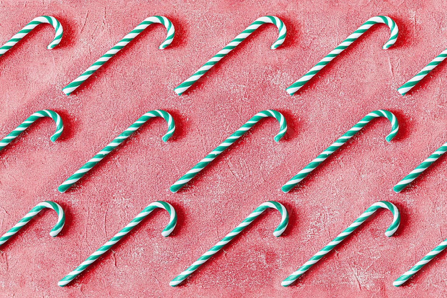 Weihnachten gestreifte Zuckerstange isoliert auf rotem Hintergrund. Zuckerstangenmuster. Ansicht von oben foto