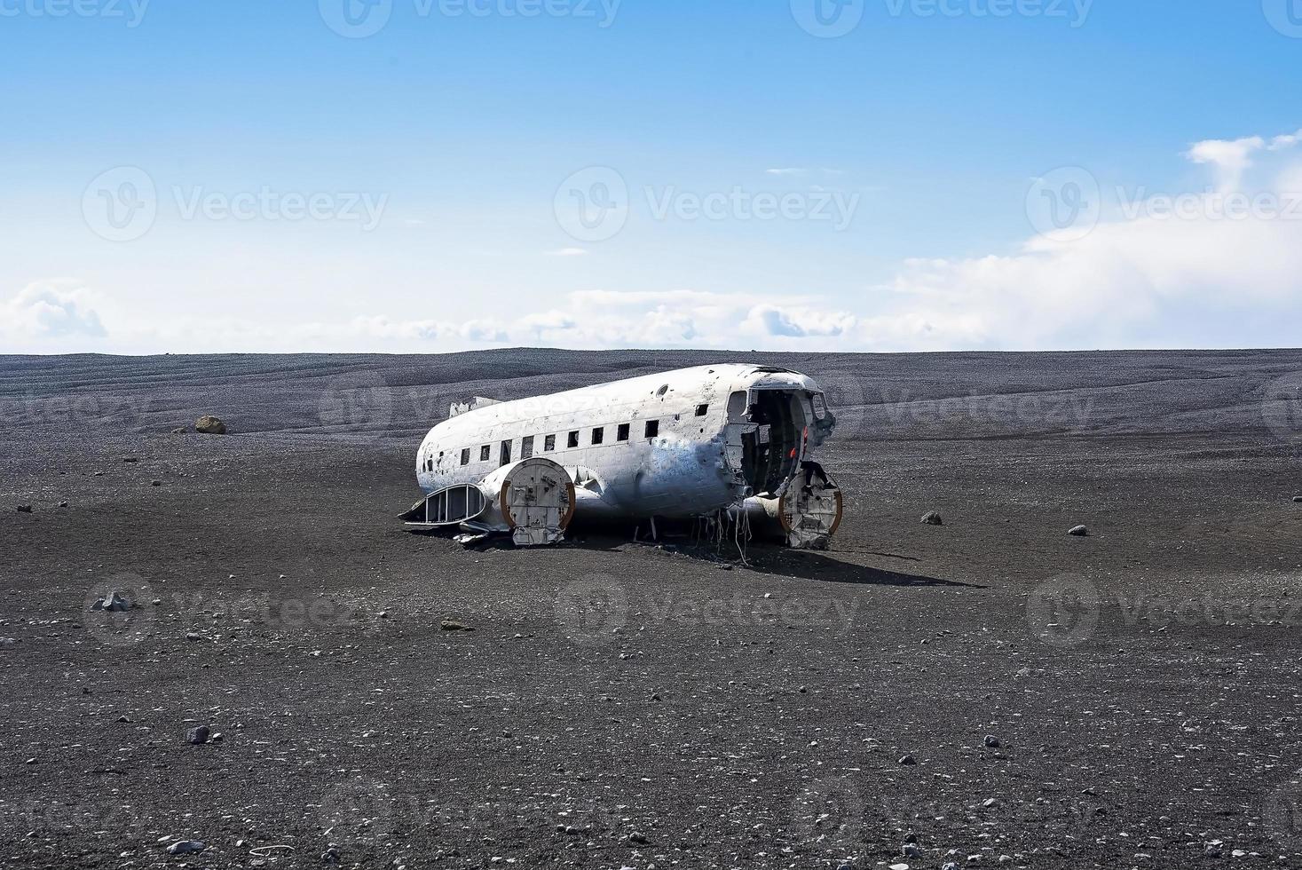 Verlassenes beschädigtes Flugzeugwrack am schwarzen Sandstrand in Solheimasandur gegen den Himmel foto