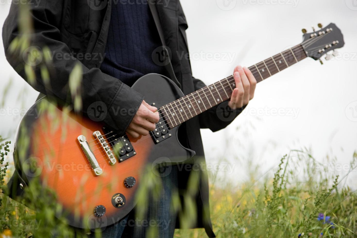 Nahaufnahme eines Mannes, der Gitarre spielt foto