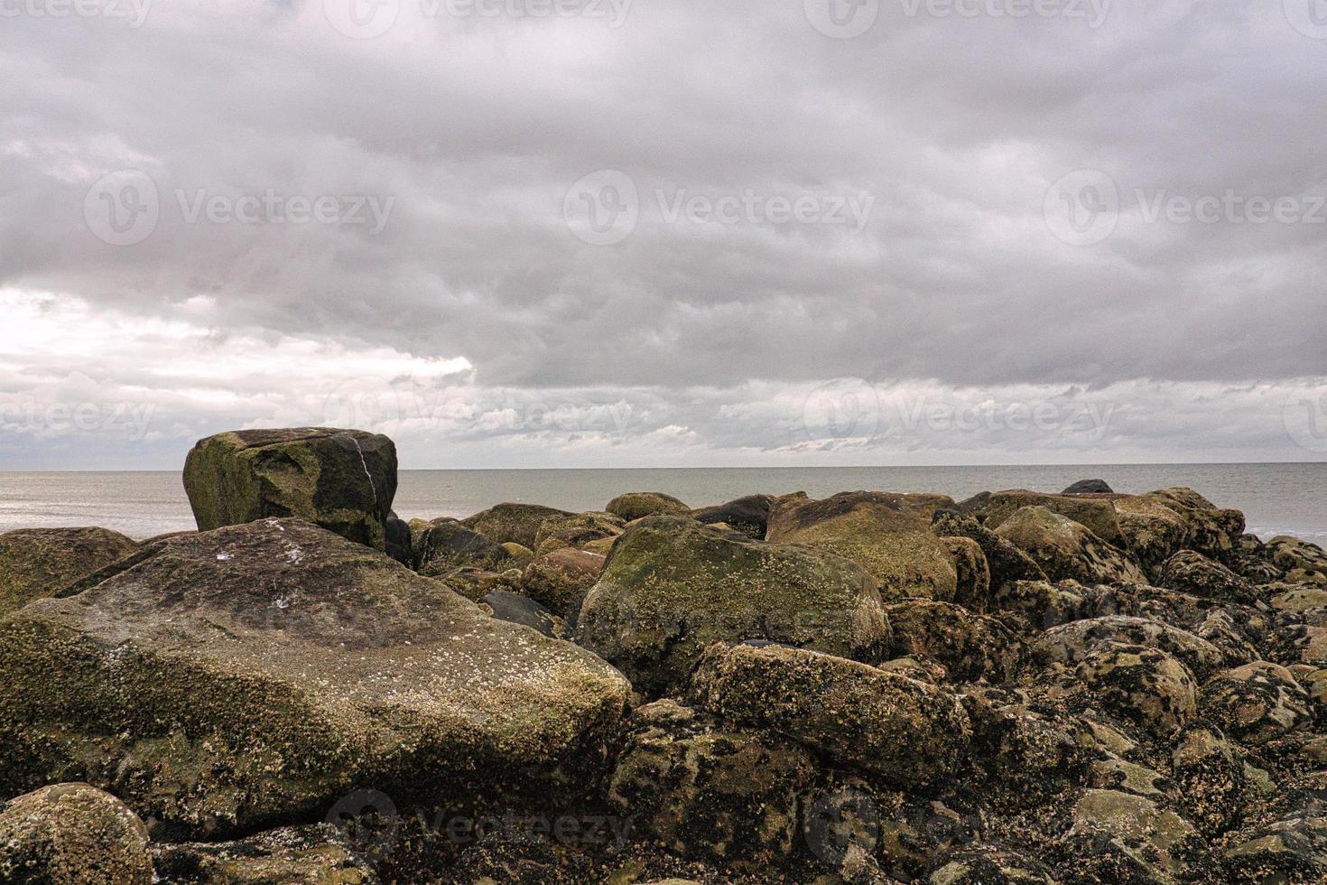 Steinbuhnen, die am Strand in Blavand, Dänemark, ins Meer gehen. Landschaftsfoto foto