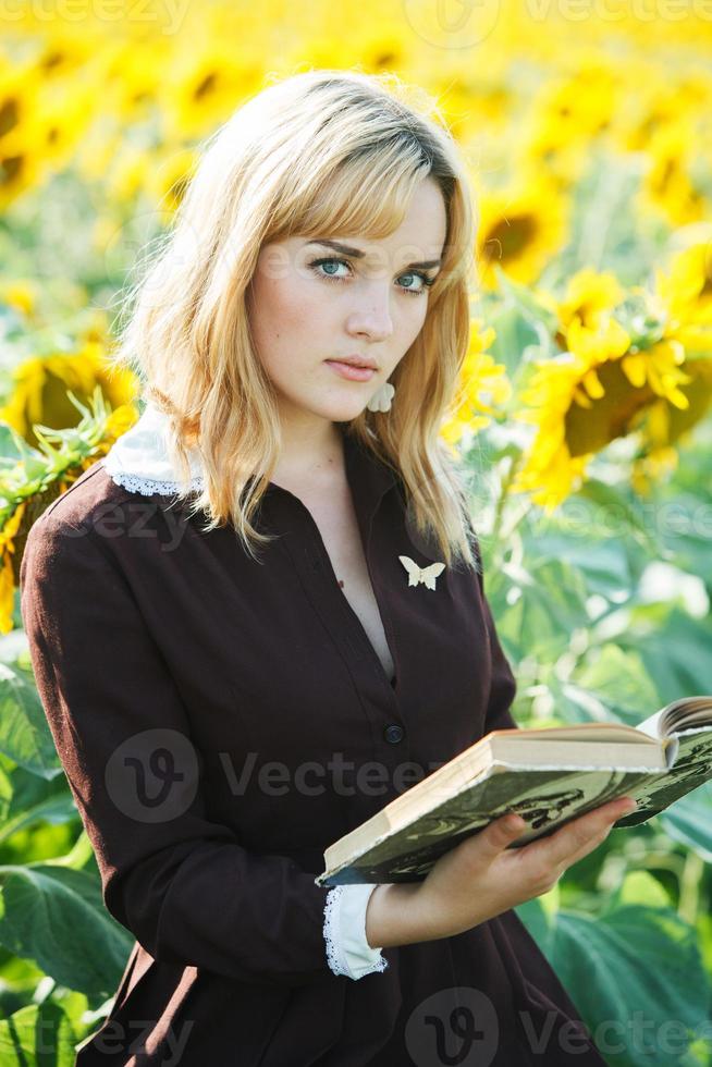 Porträt des russischen Schulmädchens im Sonnenblumenfeld foto