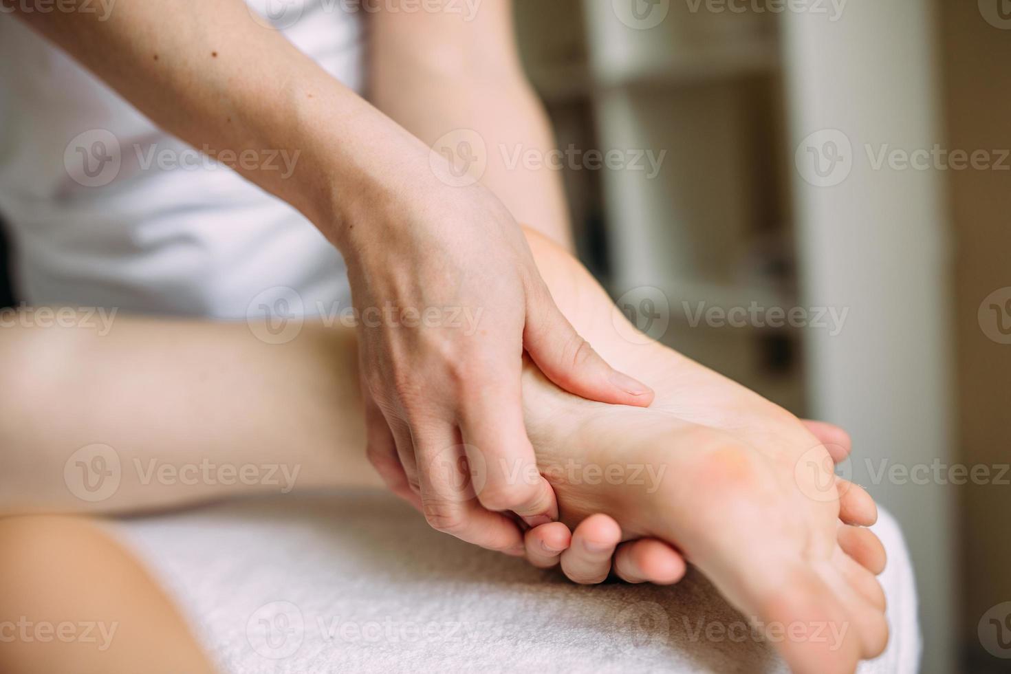 Der Masseur massiert die weiblichen Füße im Spa. das Konzept der kosmetischen Verfahren. foto