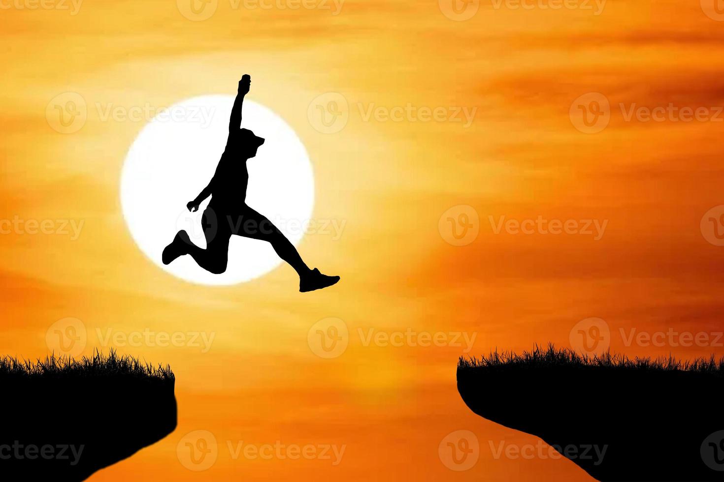 Silhouette eines Athleten, der auf einer felsigen Klippe springt foto