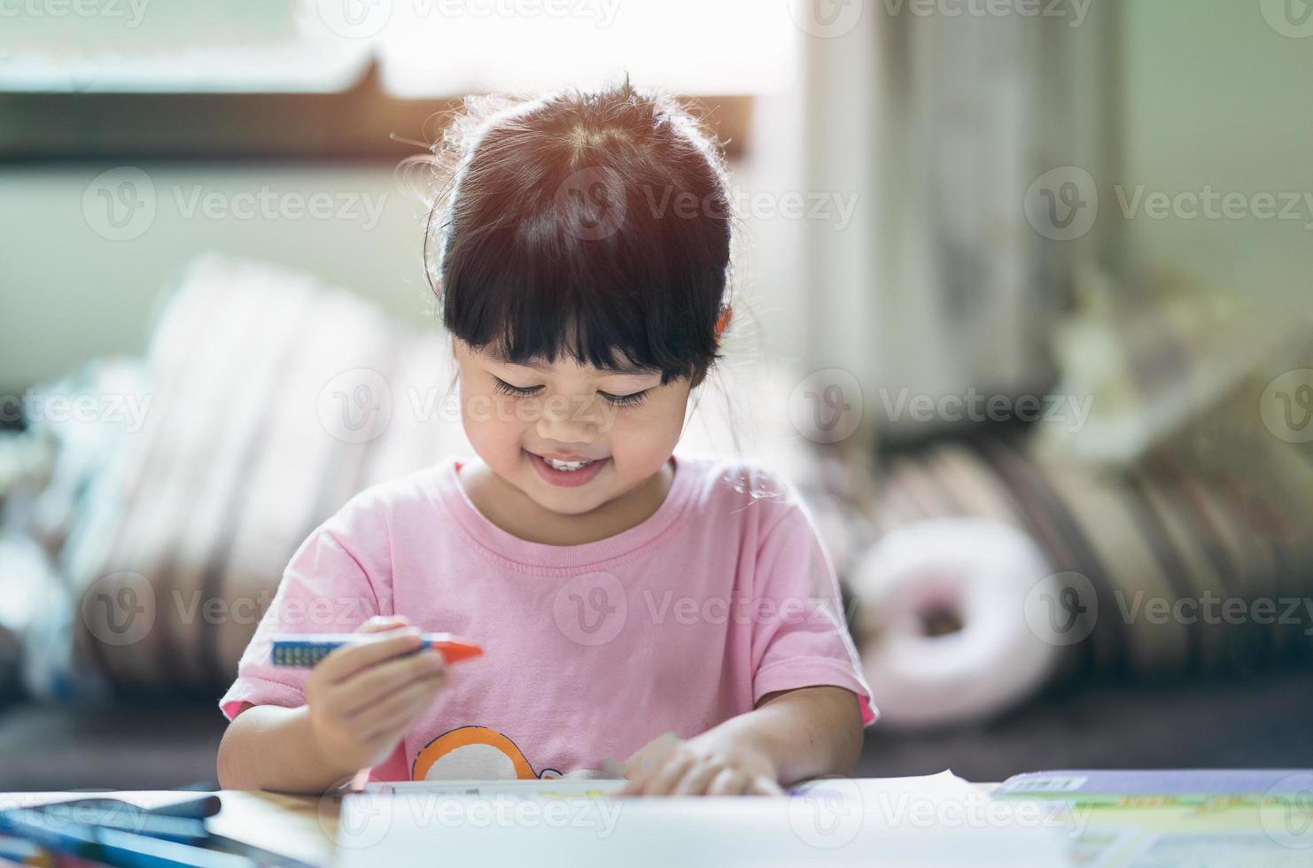 süßes kleines kind, das mit bunten farben malt. asiatisches mädchen, das kreidezeichnungsfarbe verwendet. baby-künstleraktivitäts-lifestyle-konzept. foto