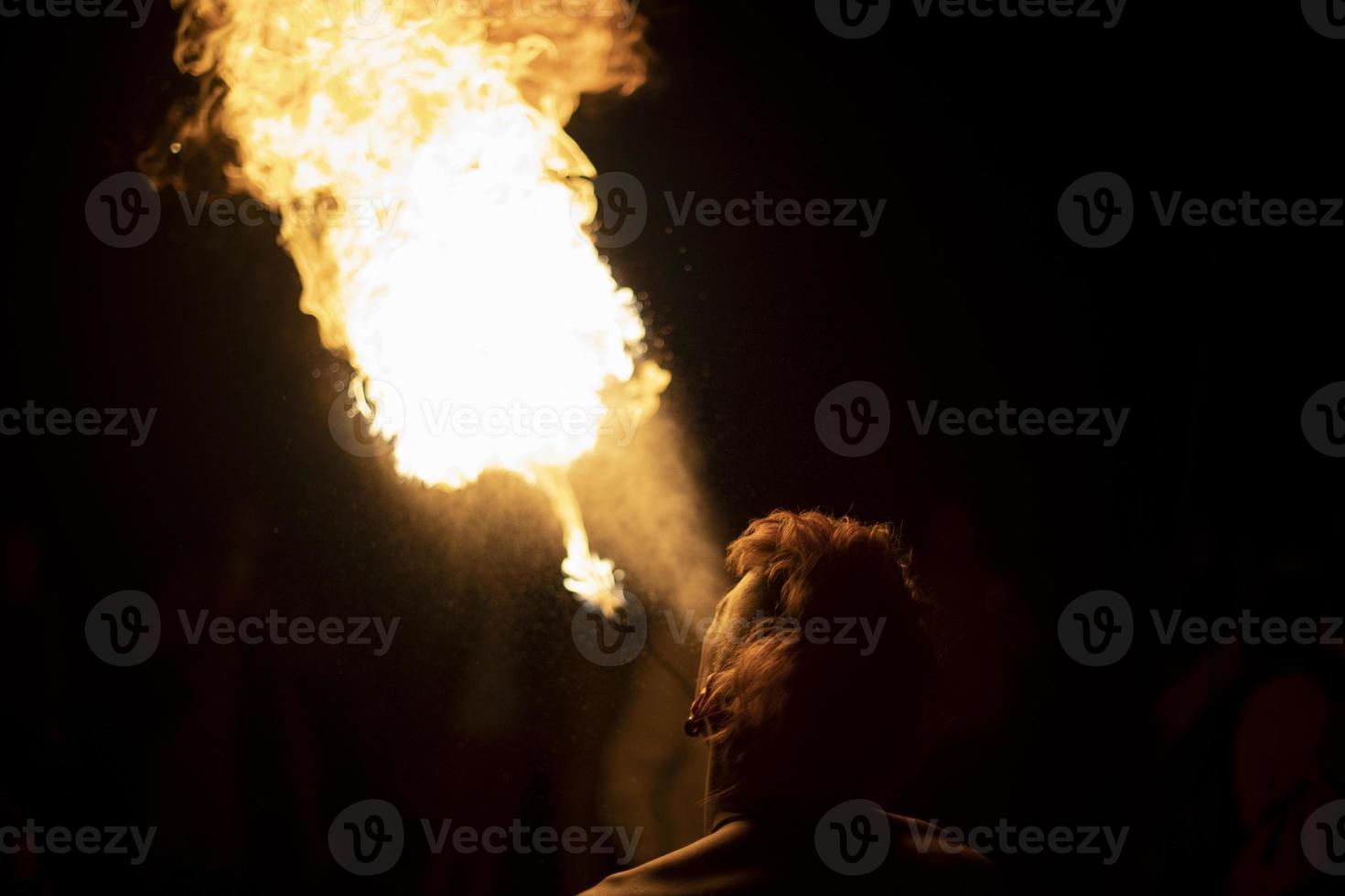 Kerl schießt aus seinem Mund. Mensch und Flamme. feuerspeiender Mann. helle Flamme. foto