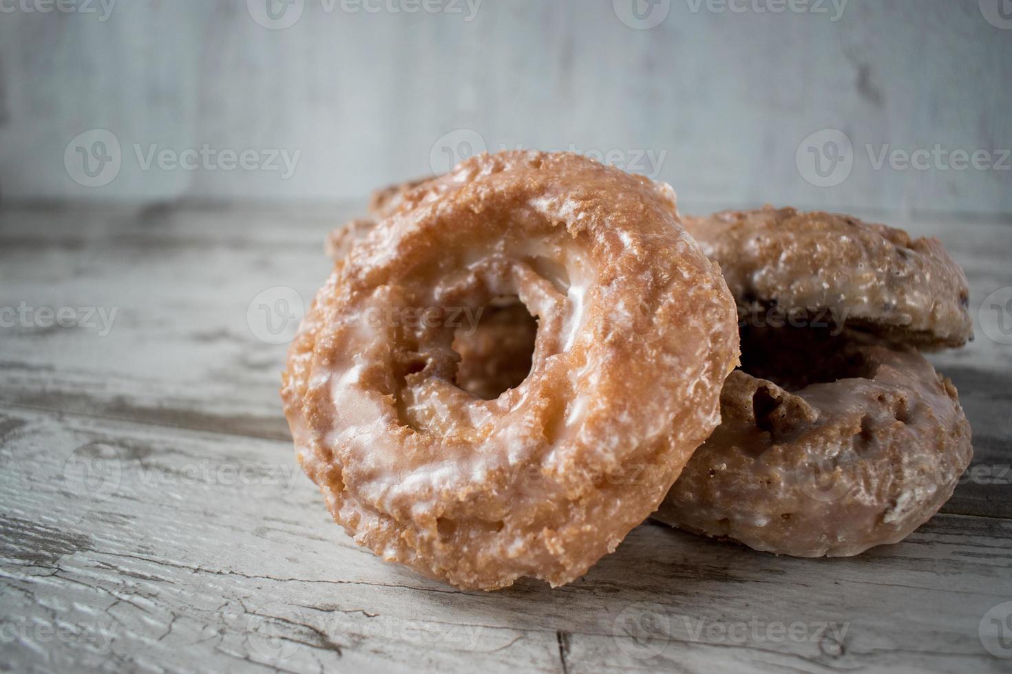 Stapel glasierter Donuts auf rustikalem Tisch foto