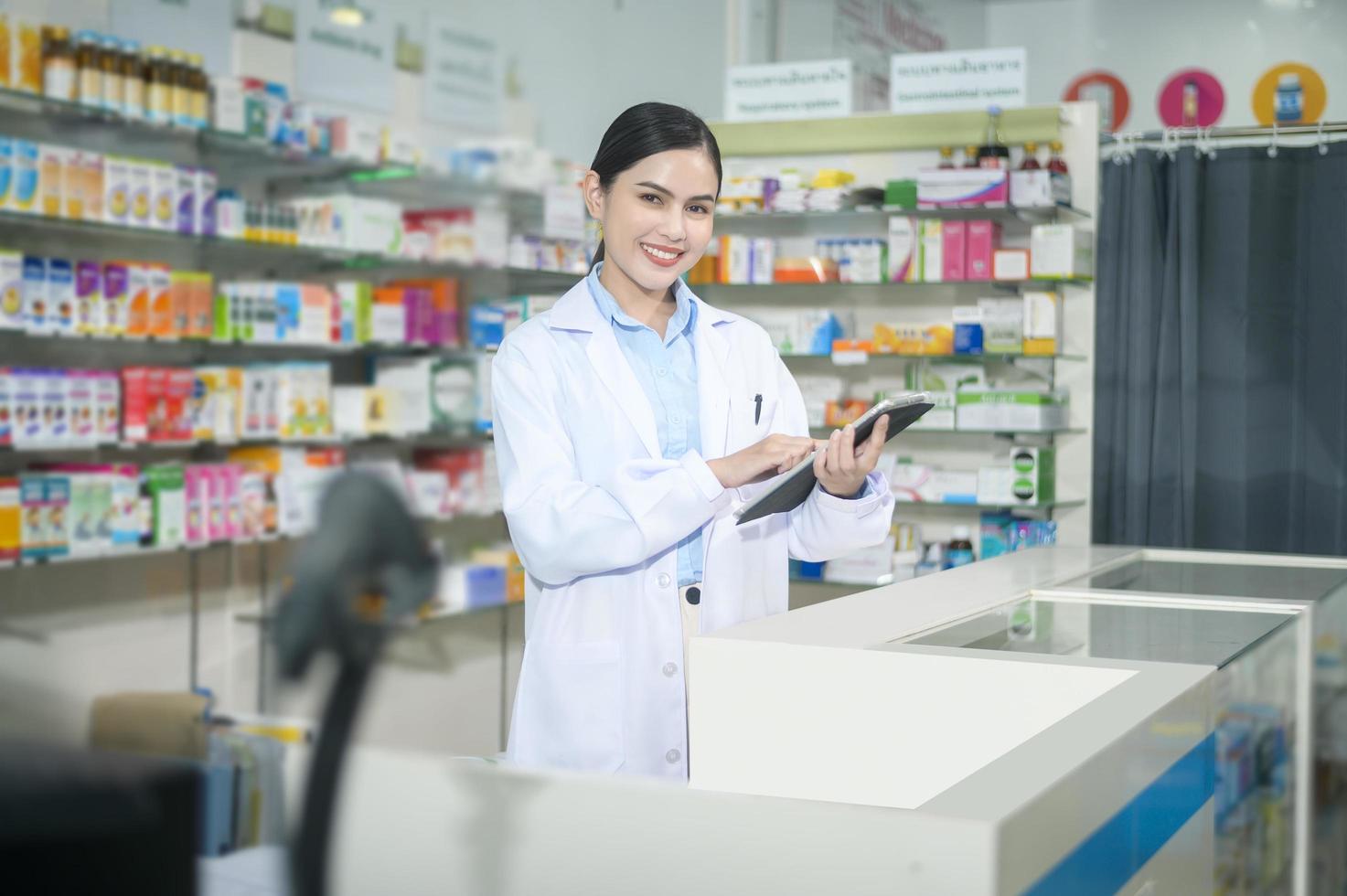 Porträt der Apothekerin mit Tablet in einer modernen Apotheke Drogerie. foto