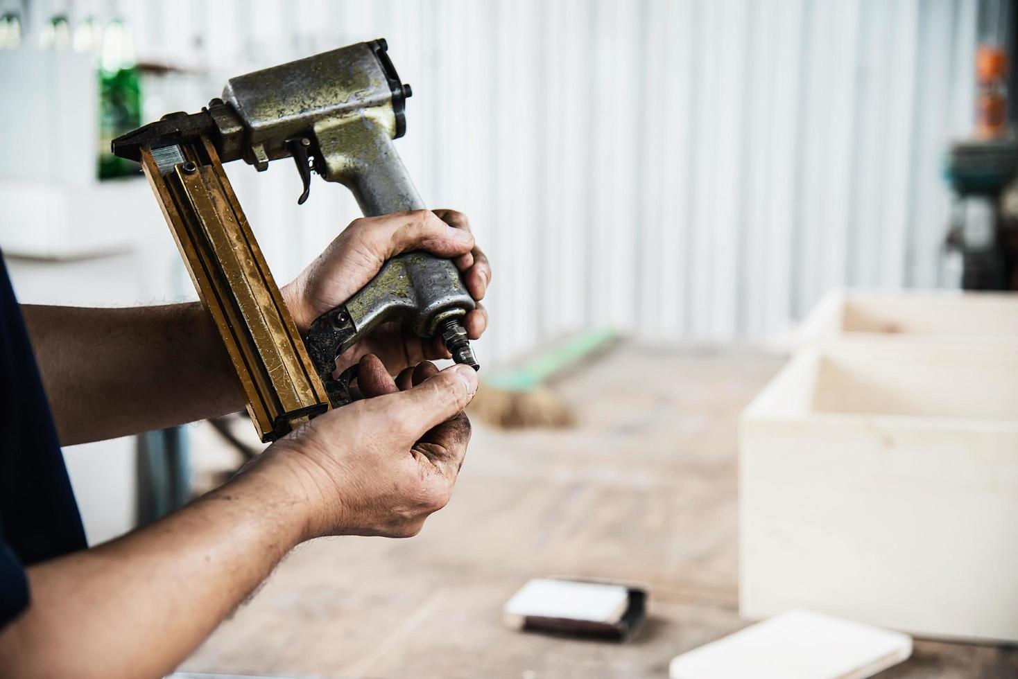 tischler, der mit der produktvorbereitung von holzmöbeln unter verwendung von handwerkzeugen und maschinentischstation arbeitet foto