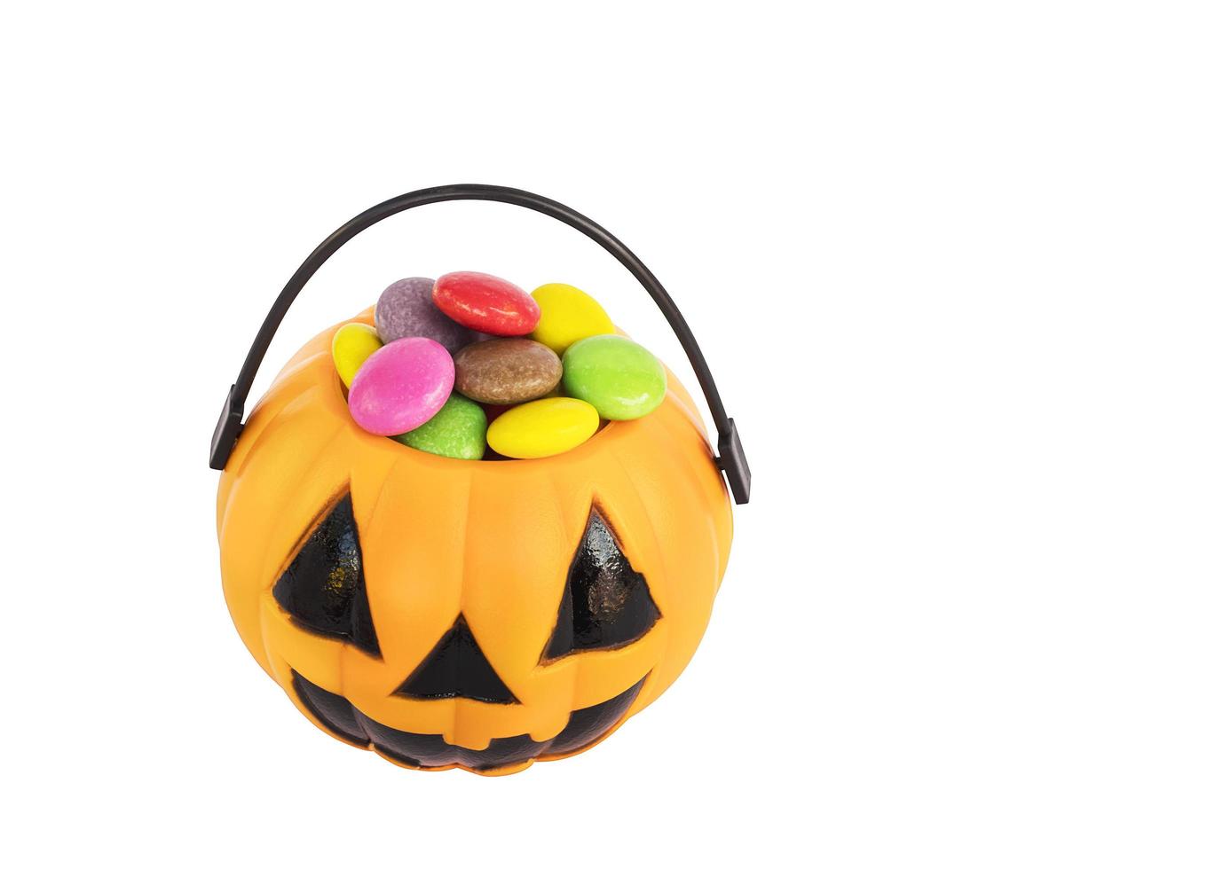 Halloween-Kürbis-Gesicht-Eimer mit bunten Süßigkeiten im Inneren isoliert über weiß. Foto enthält Beschneidungspfad.