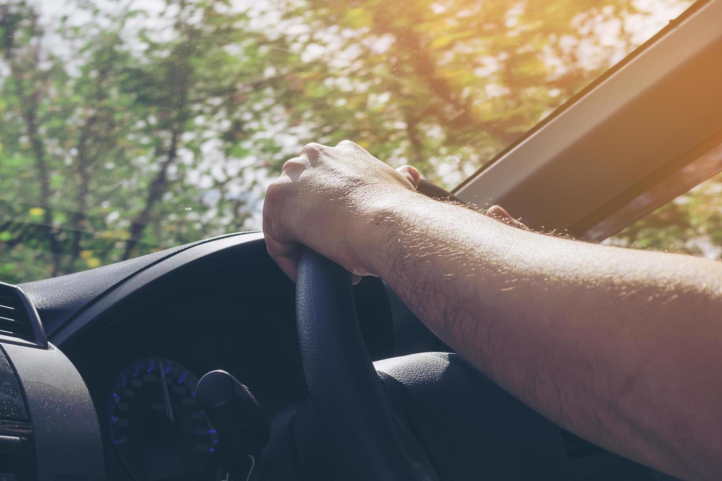 Mann fährt Auto mit einer Hand foto