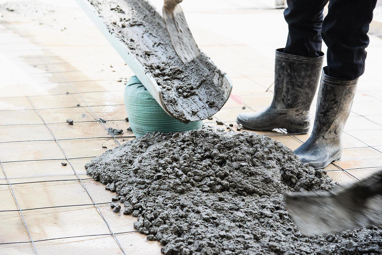 arbeiter, der bodenbetongießarbeiten auf der baustelle durchführt foto