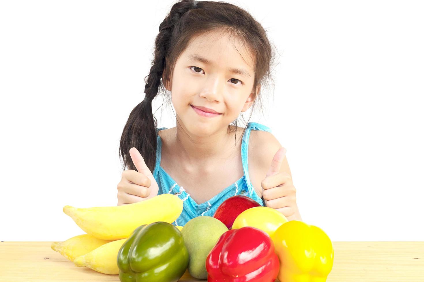 asiatisches gesundes gril, das glücklichen ausdruck mit vielzahl buntem obst und gemüse über weißem hintergrund zeigt foto