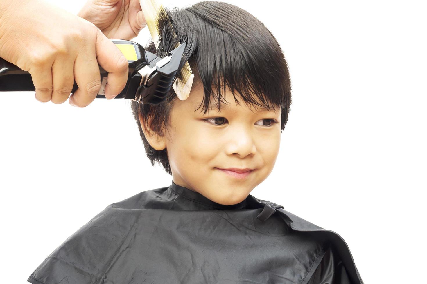 ein junge wird seine haare vom friseur isoliert auf weißem hintergrund geschnitten foto