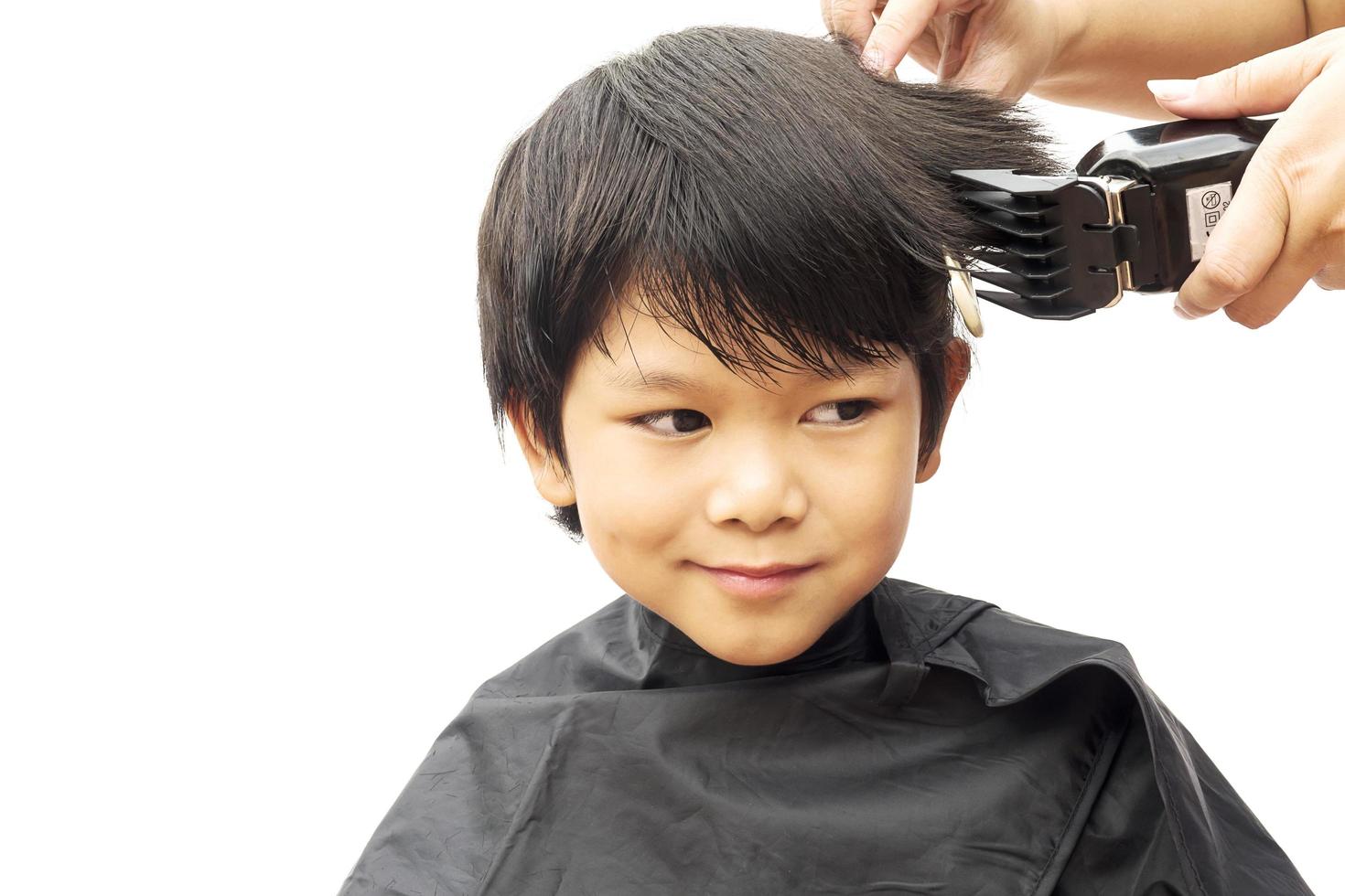 ein junge wird seine haare vom friseur isoliert auf weißem hintergrund geschnitten foto