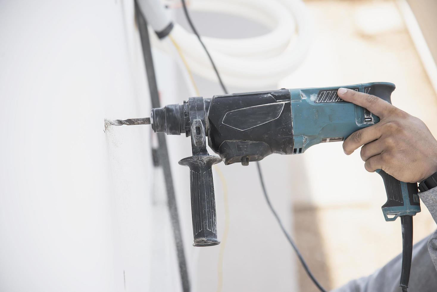 Der Mensch installiert während der heißen Jahreszeit einen Wandkompressor der Klimaanlage foto