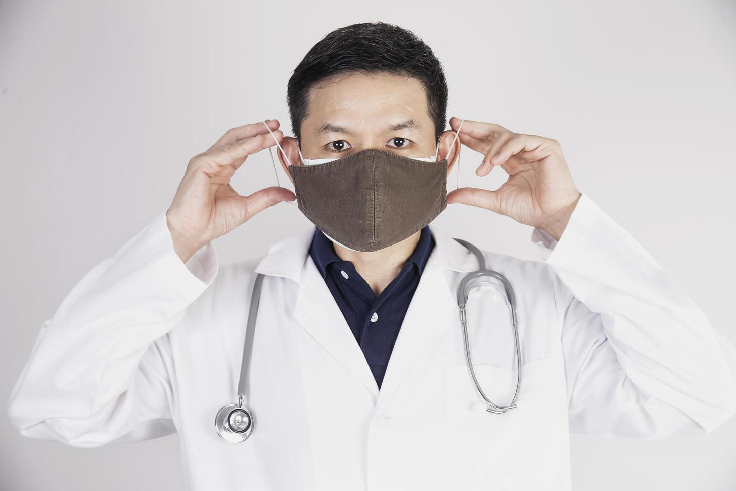 asiatischer arzt trägt doppelschichtmasken zum schutz des covid-19-virus - arbeitskonzept für medizinische menschen foto