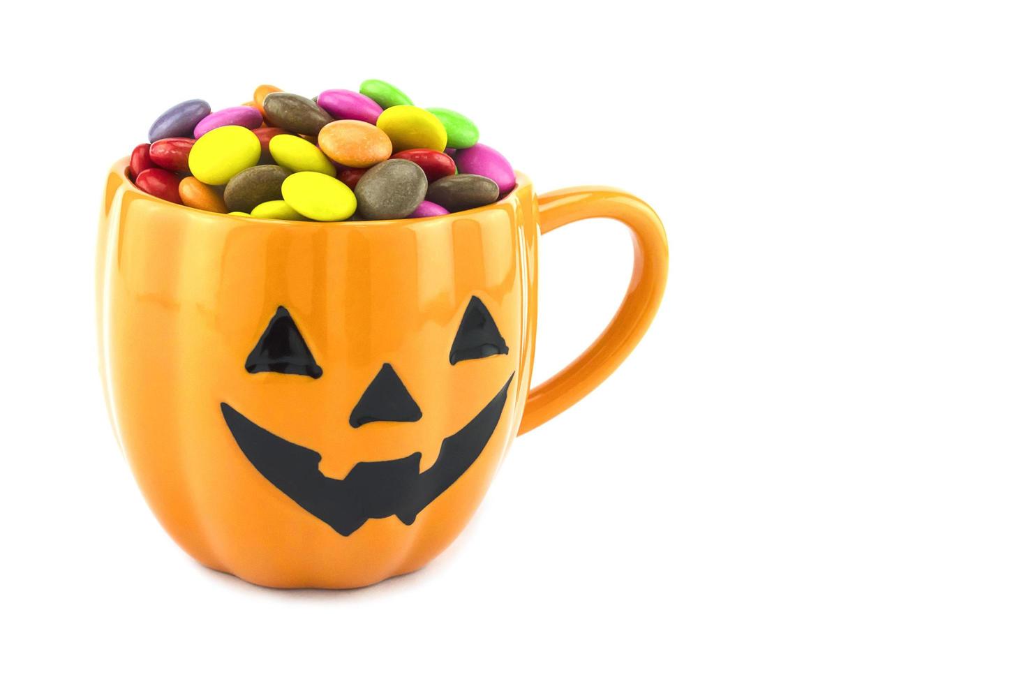 Halloween-SüßigkeitenHalloween-Süßigkeiten Tasse isoliert über weiß foto