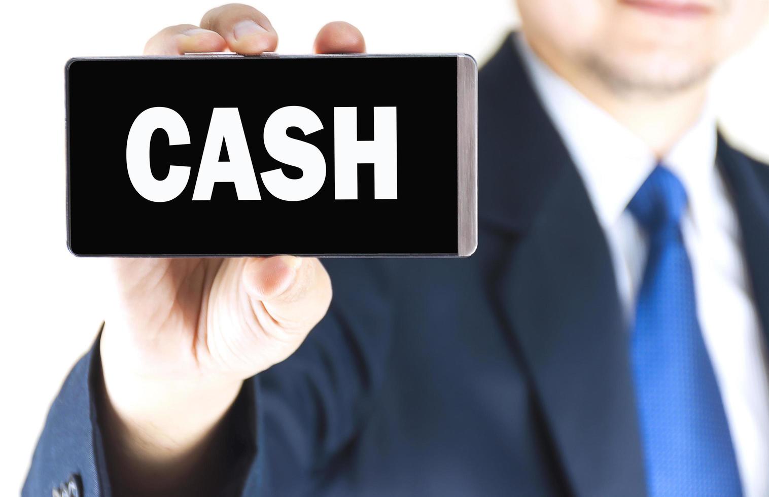 Cash-Wort auf Handy-Bildschirm in verschwommenen jungen Geschäftsmann überreichen weißen Hintergrund, Geschäftskonzept foto