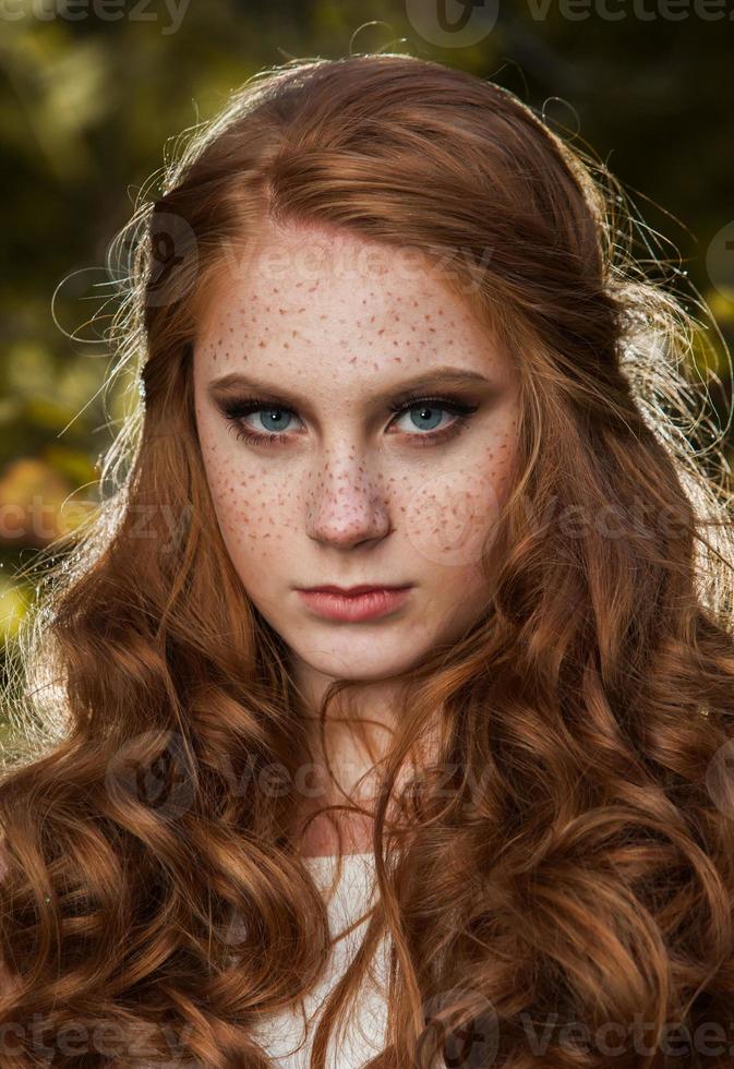 junge frau, die ein paar gelbe ahornblätter hält. Herbstportrait der jungen Frau. rothaariges Mädchen im Herbstwald foto