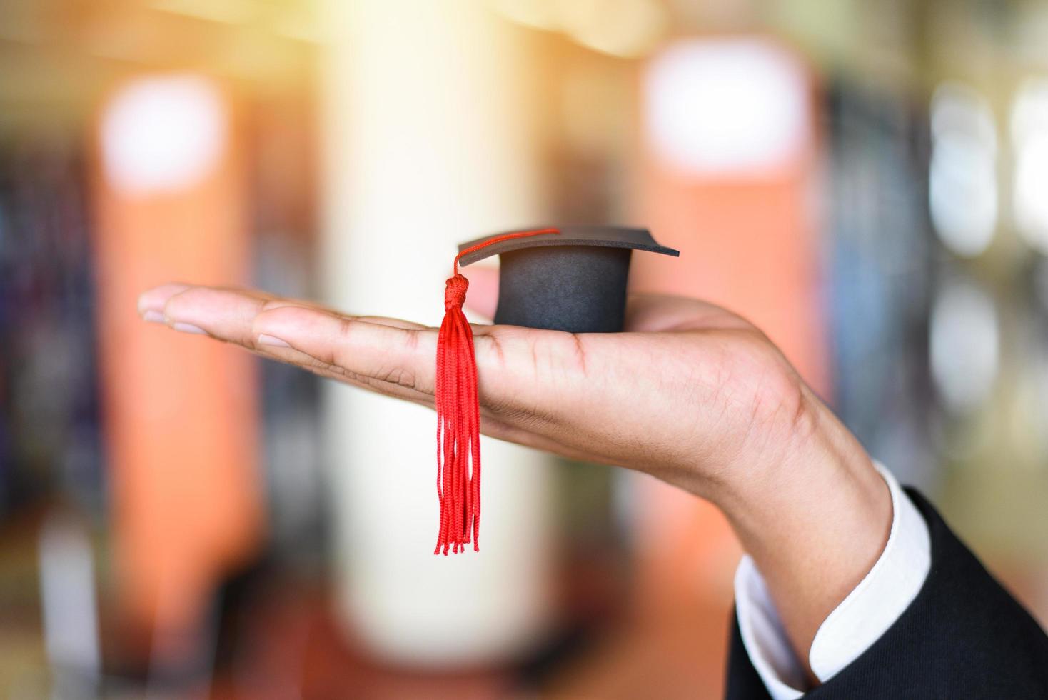 geschäftsmann oder student mit graduierungskappe bei der tagesgraduierung gratulierten den graduierten in der bibliothek an der universität - graduierungsausbildung betriebswirtschaftliches studienkonzept foto