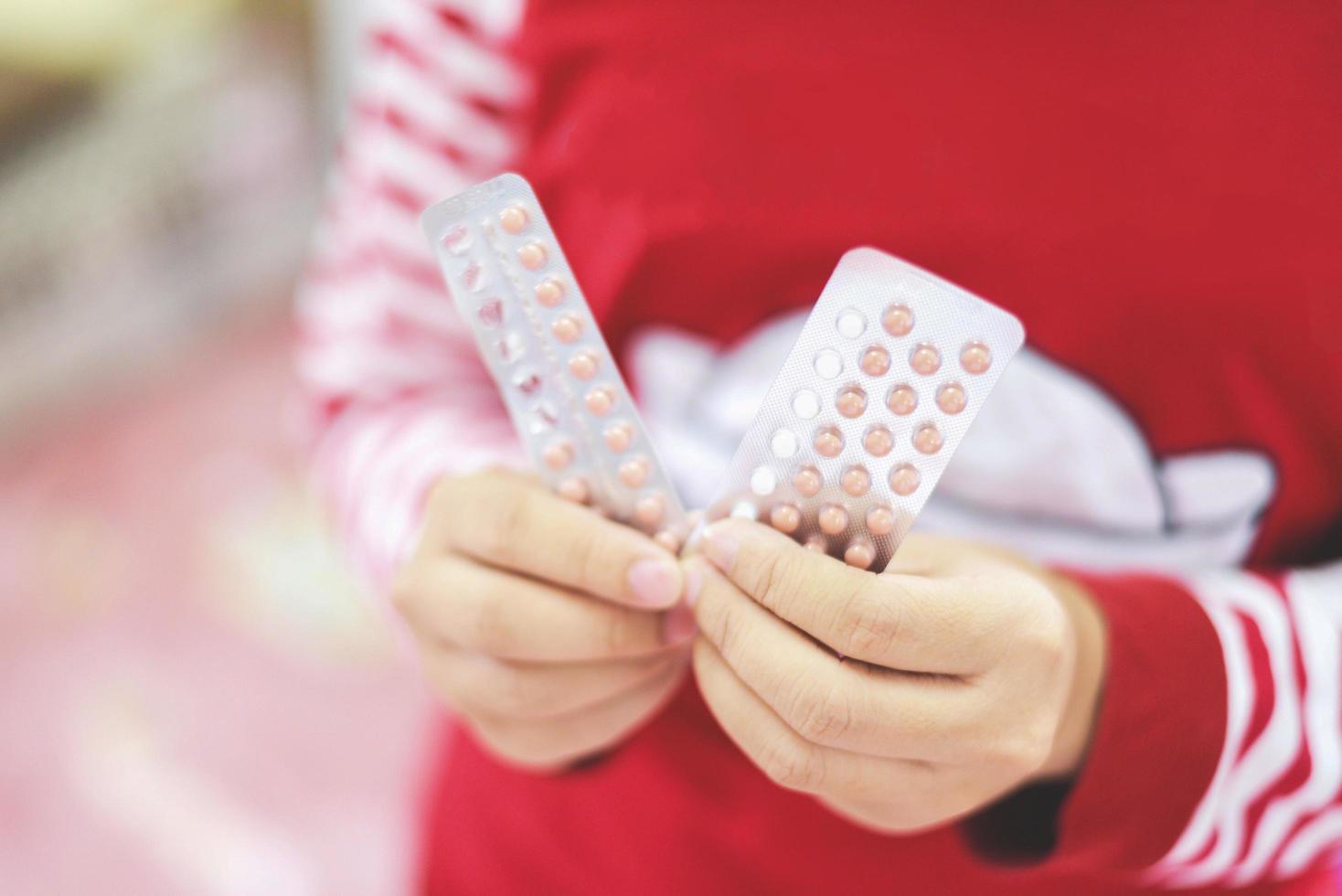 Empfängnisverhütungspillen in der Hand Frau hält - Empfängnisverhütungsmethoden zur Empfängnisverhütung verhindern eine Schwangerschaft foto