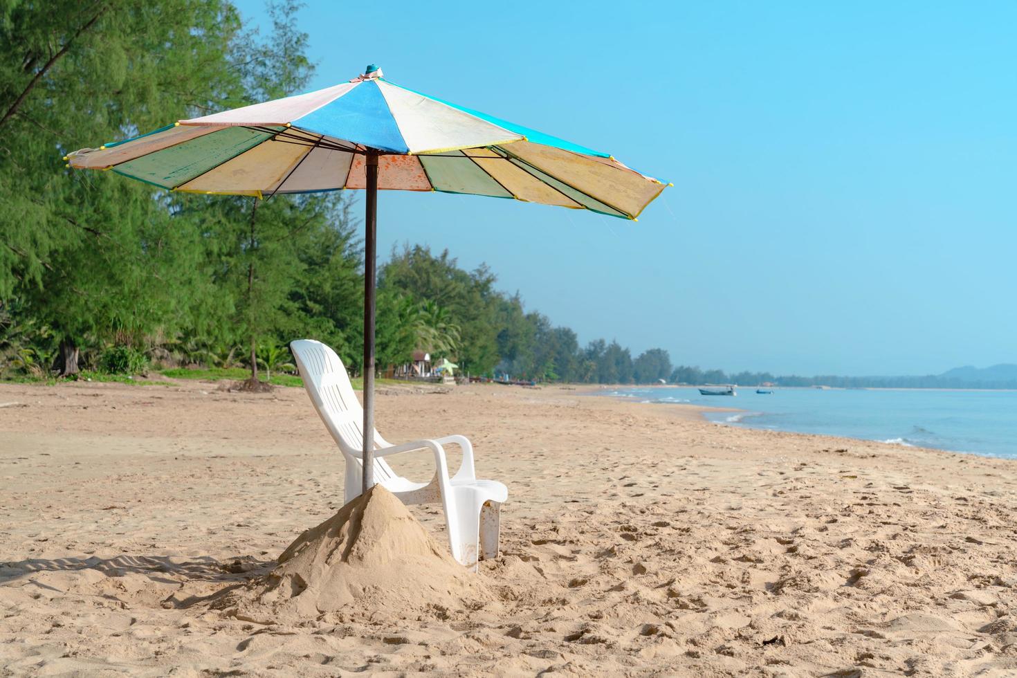 weißer Liegestuhl und Sonnenschirm am tropischen Strand mit blauem Himmel foto