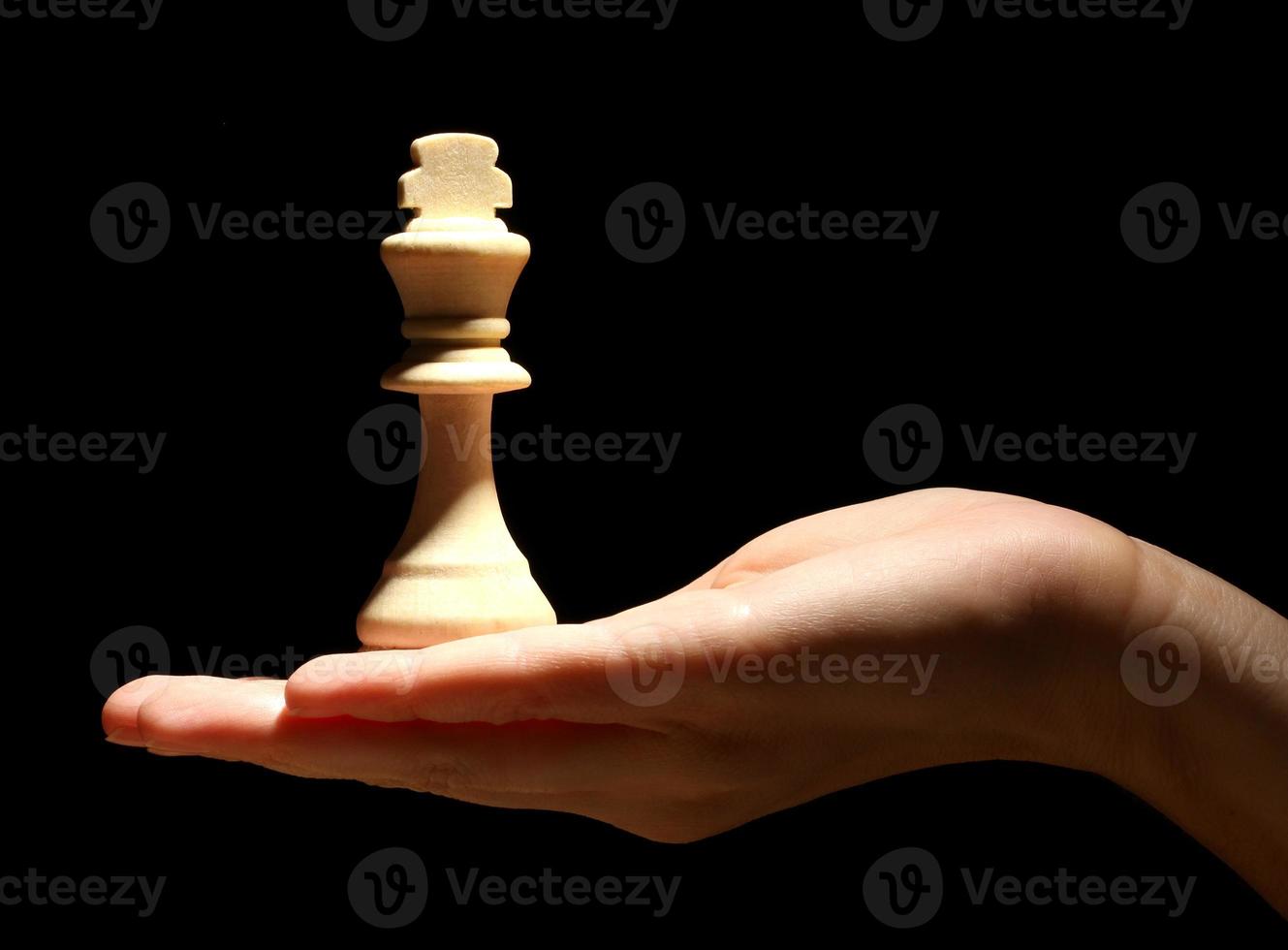 Schachfigur in der Hand isoliert auf schwarz foto