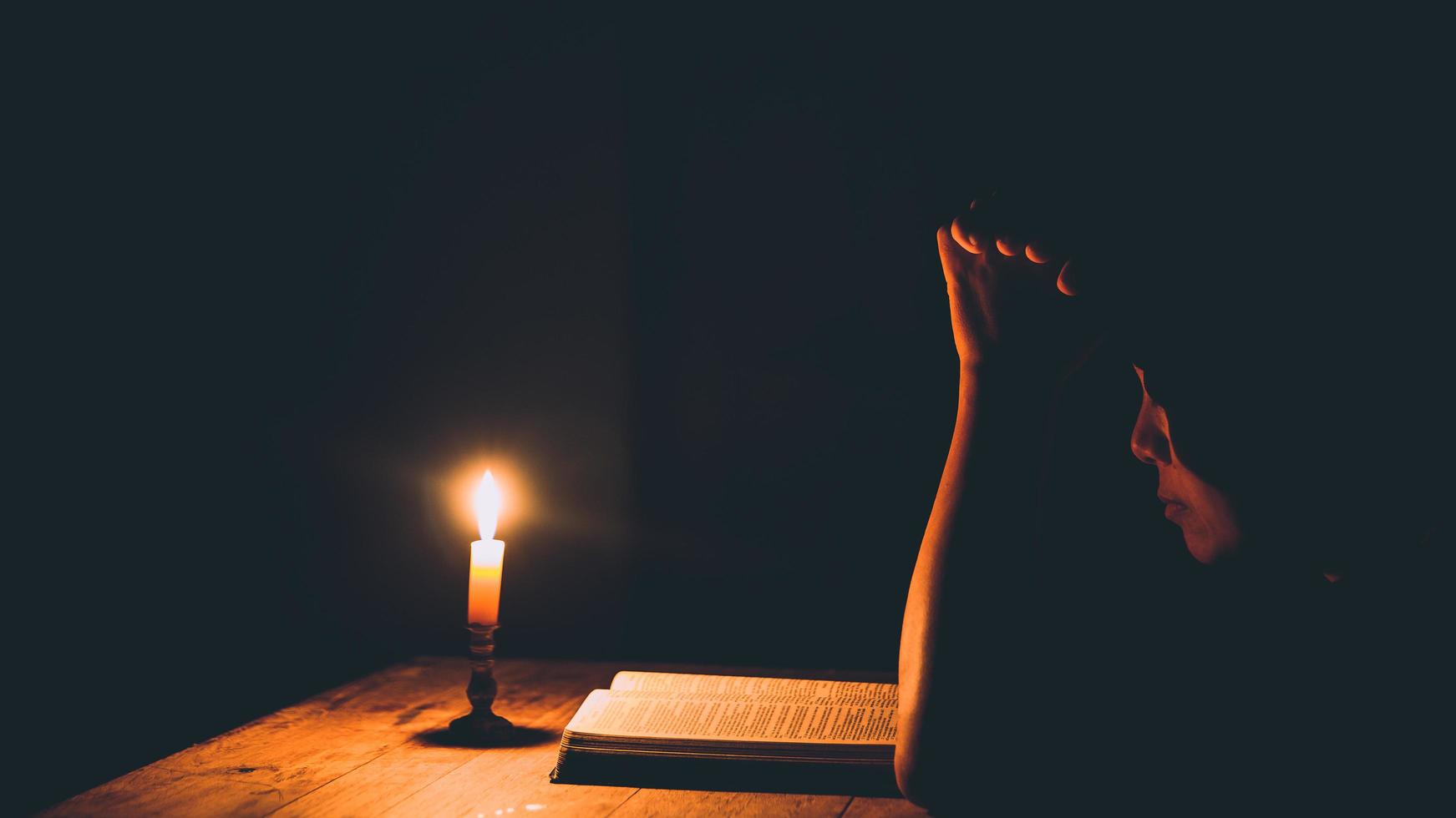 Frau, die in den Lichtkerzen betet foto