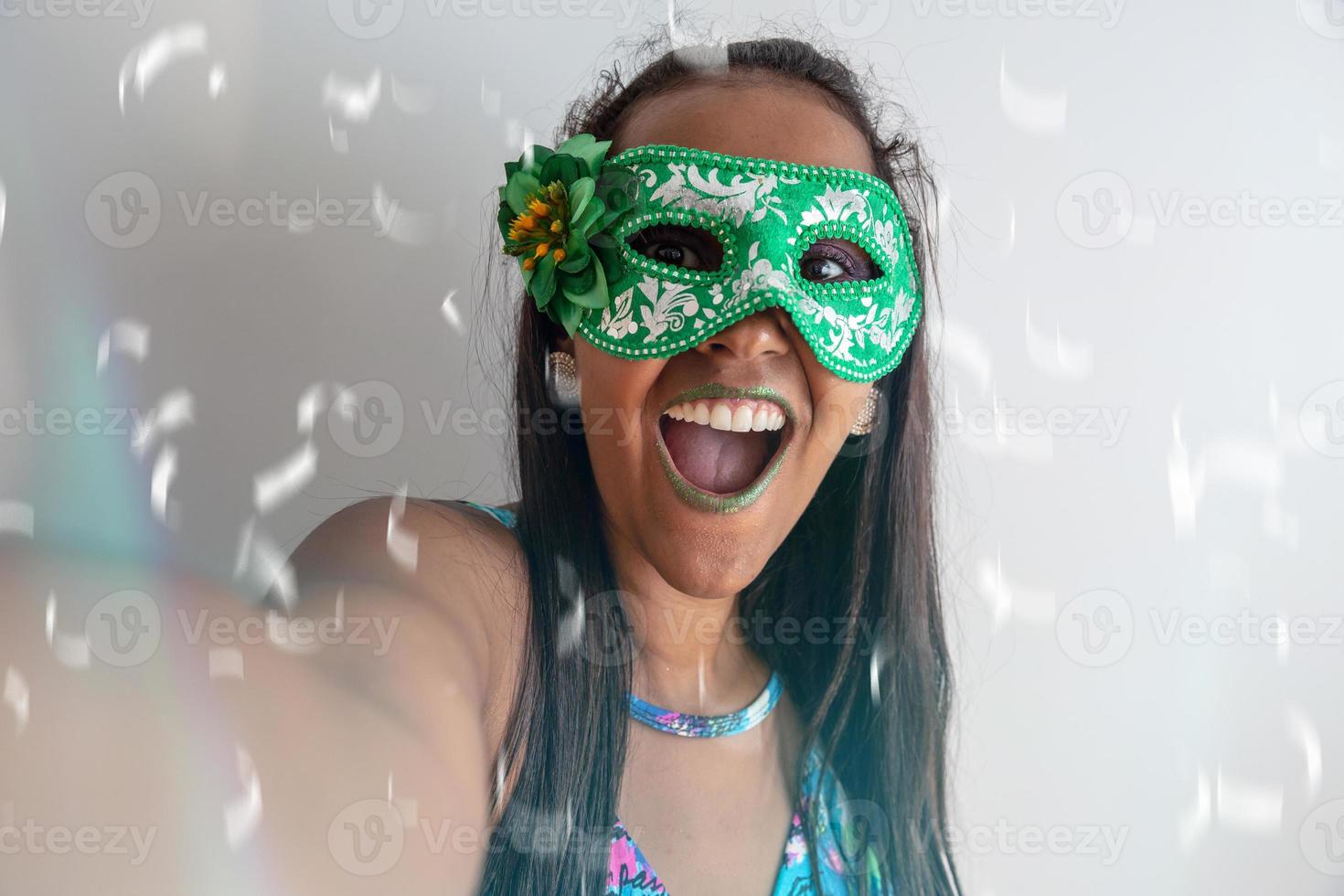 glückliche junge frau mit maske und konfetti auf karnevalsparty. brasilianischer Karneval foto