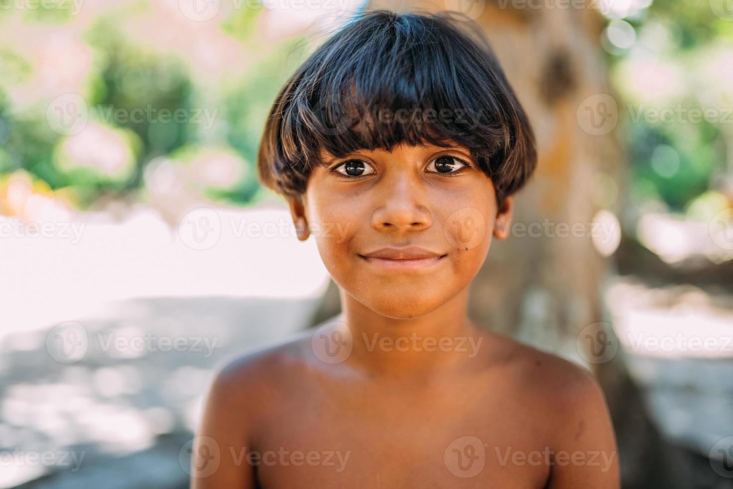 junger Indianer vom Pataxo-Stamm im Süden Bahias. indisches Kind lächelt und schaut in die Kamera. Konzentrieren Sie sich auf das Gesicht foto