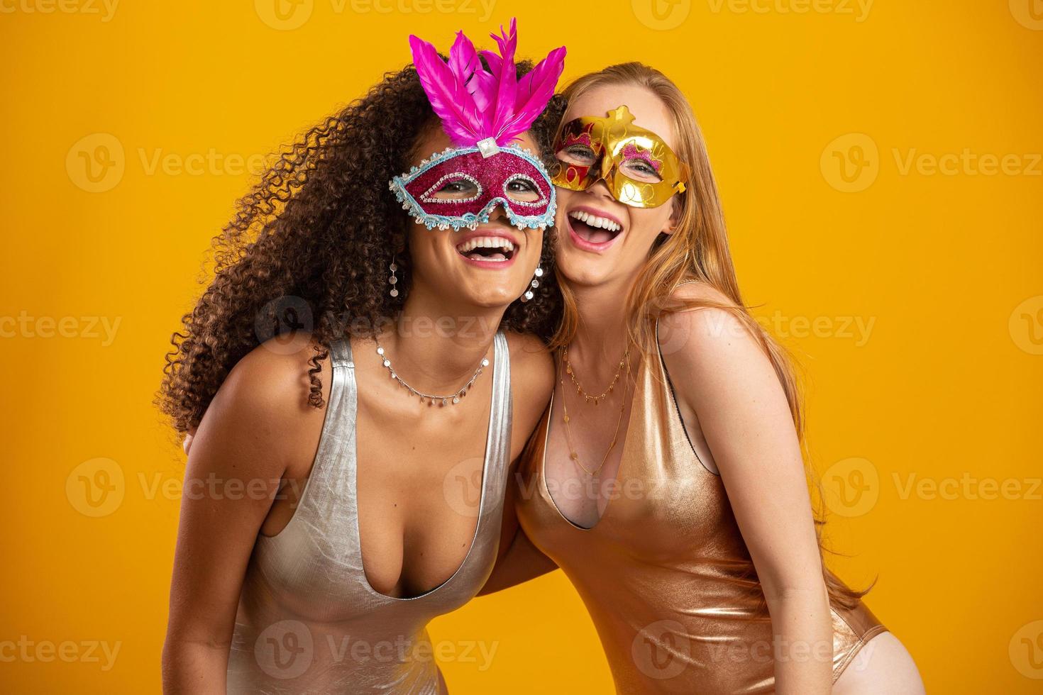 schöne frauen, die für die karnevalsnacht gekleidet sind. lächelnde frauen bereit, den karneval mit einer bunten maske zu genießen. foto