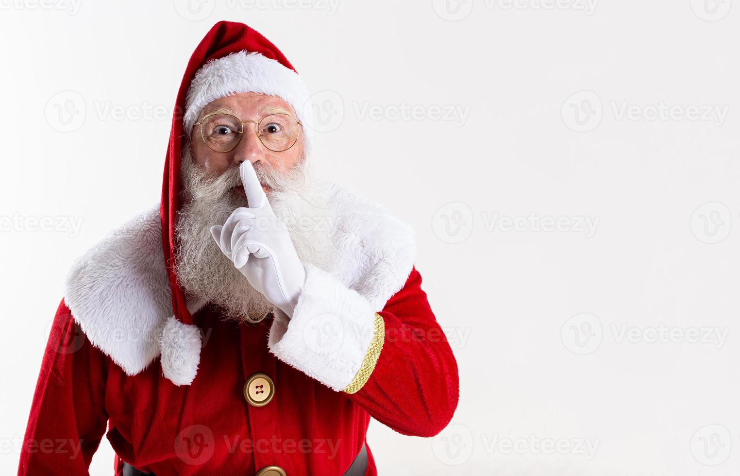 weihnachtsmann, der zeigefinger durch seinen mund hält. shh geheim halten. still vertraulich. foto
