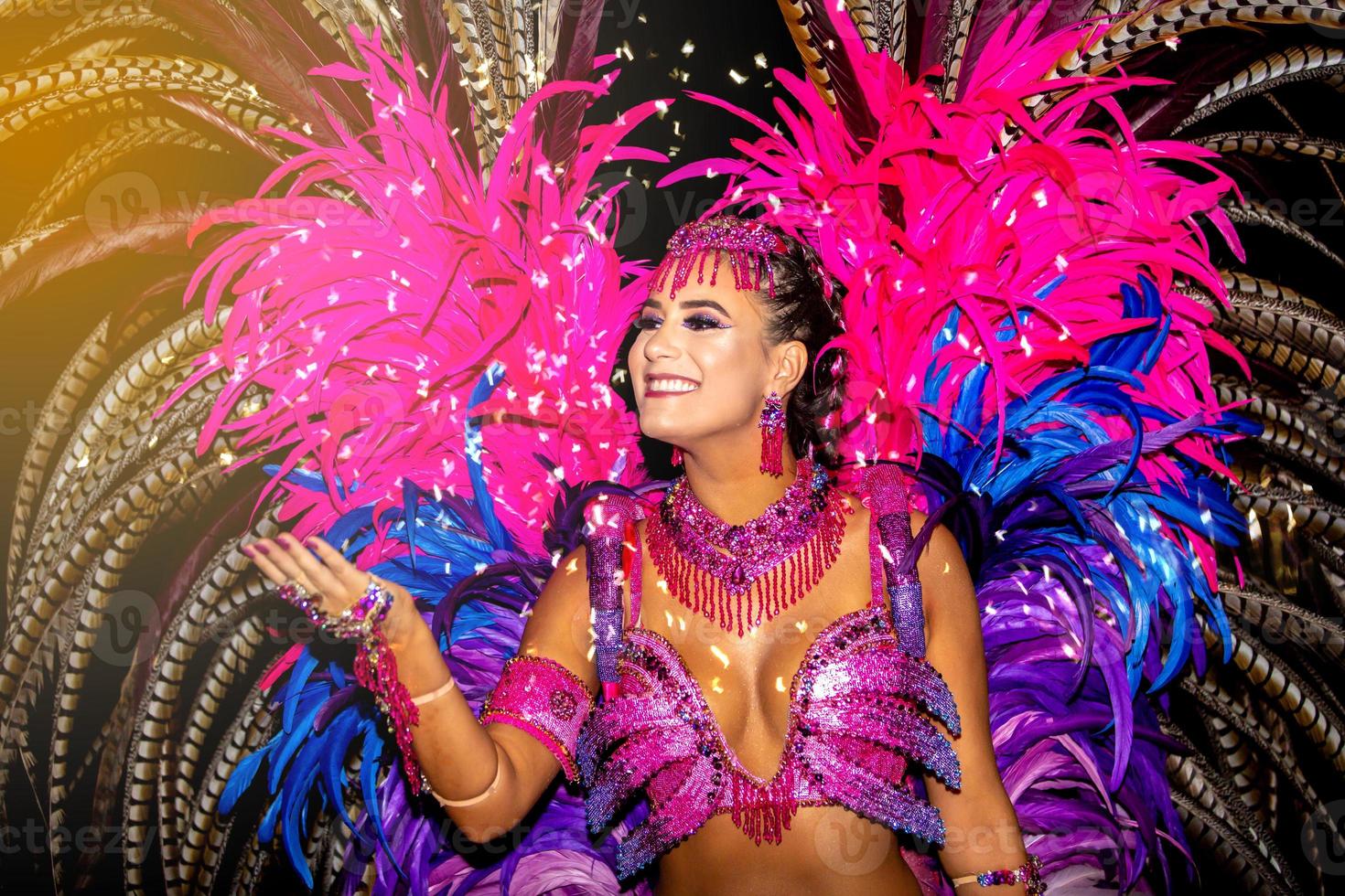 Brasilianer mit Samba-Kostüm. schöne brasilianische frau, die bunte kostüme trägt und während der carnaval street parade in brasilien lächelt. foto